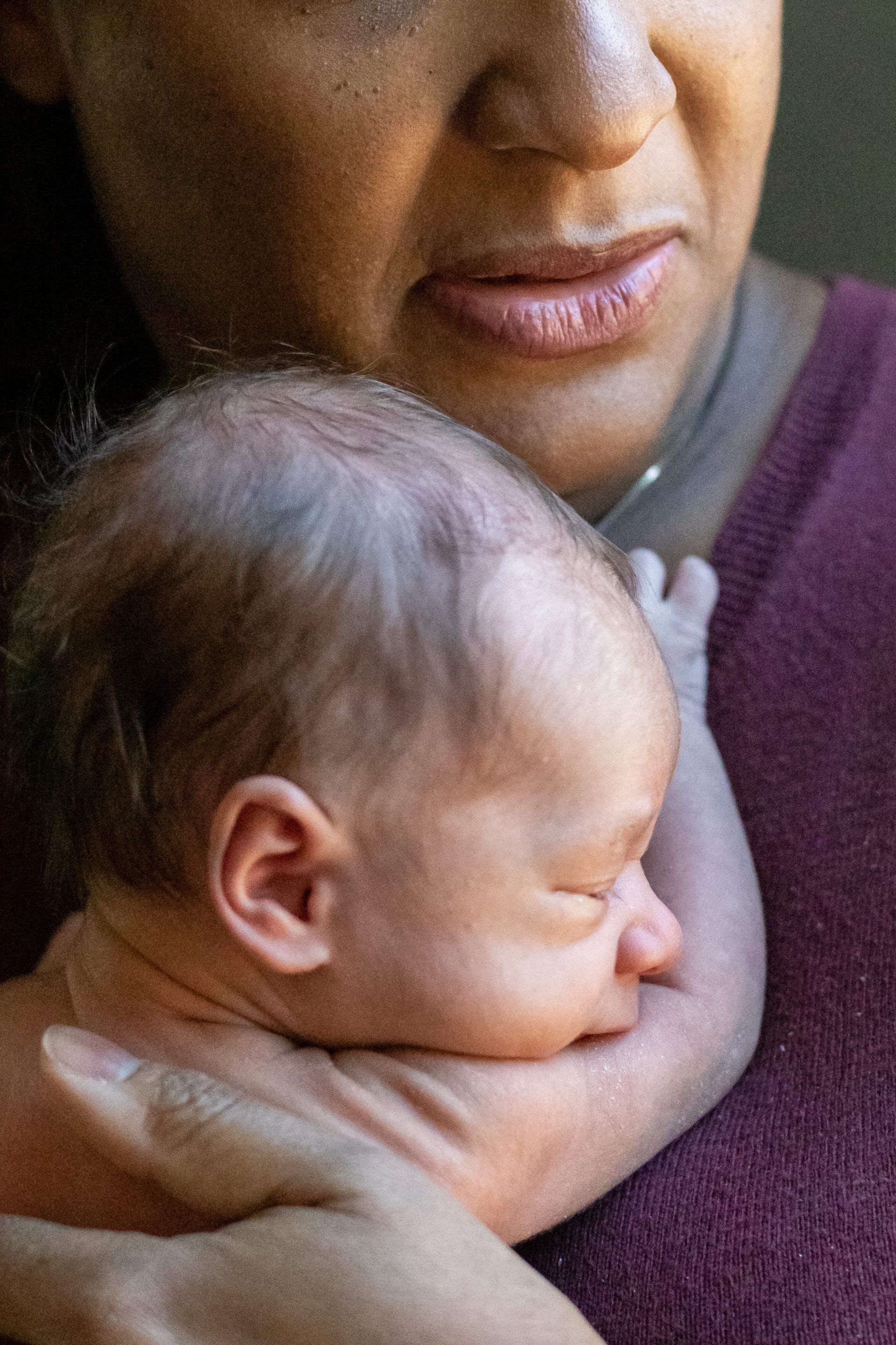 A woman is holding a newborn baby in her arms.