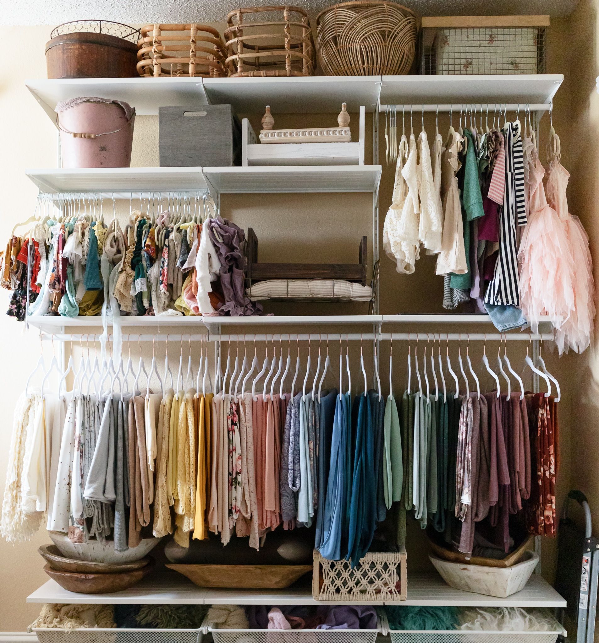 A closet filled with lots of clothes and baskets.