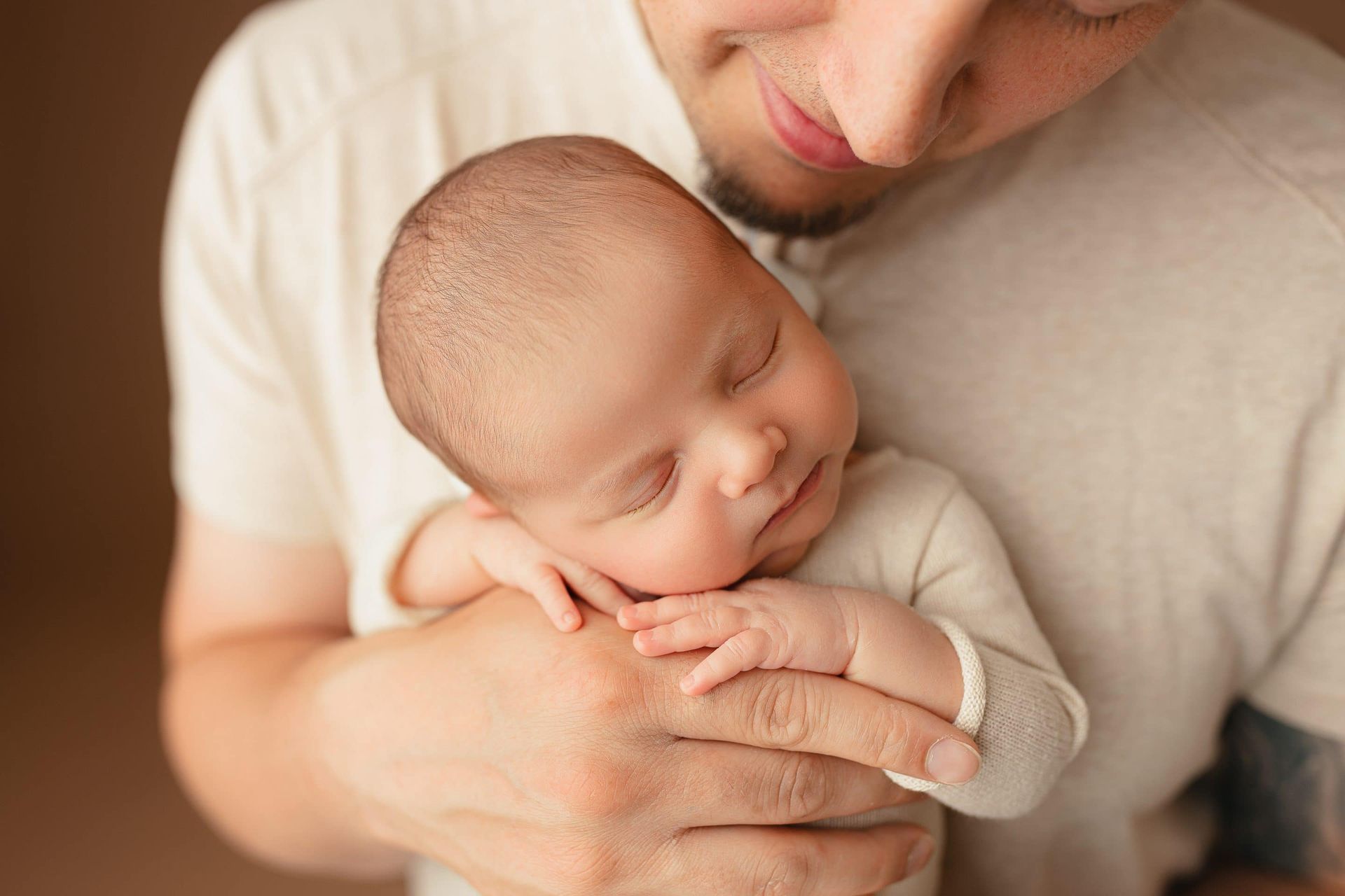 A man is holding a newborn baby in his arms.