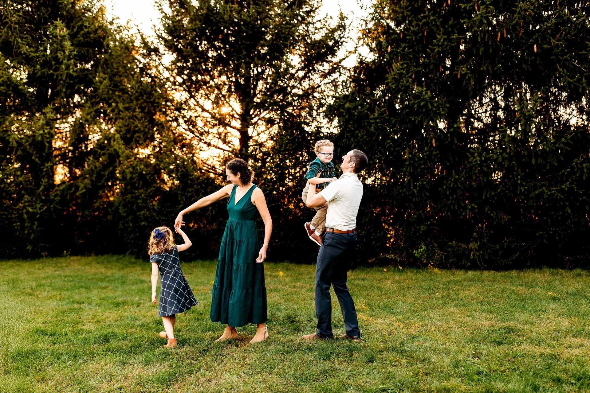 A family is standing in a grassy field holding hands.