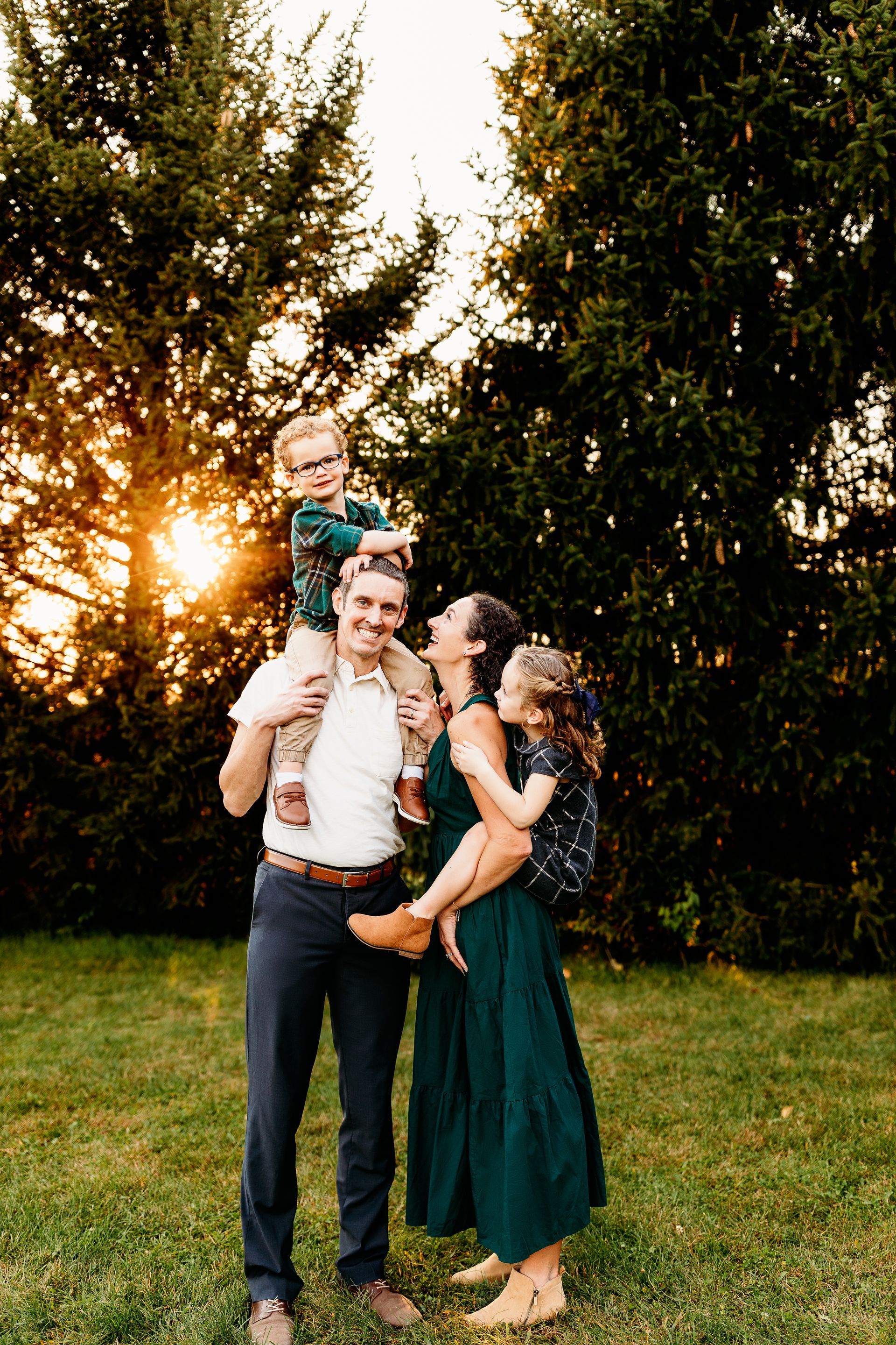 A family is posing for a picture in a grassy field.