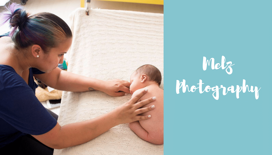 A woman is holding a newborn baby on a bed.