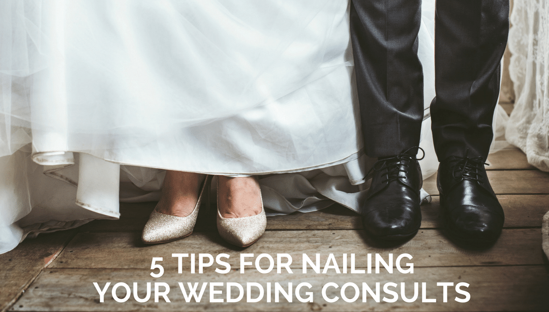 A bride and groom are standing next to each other on a wooden floor.