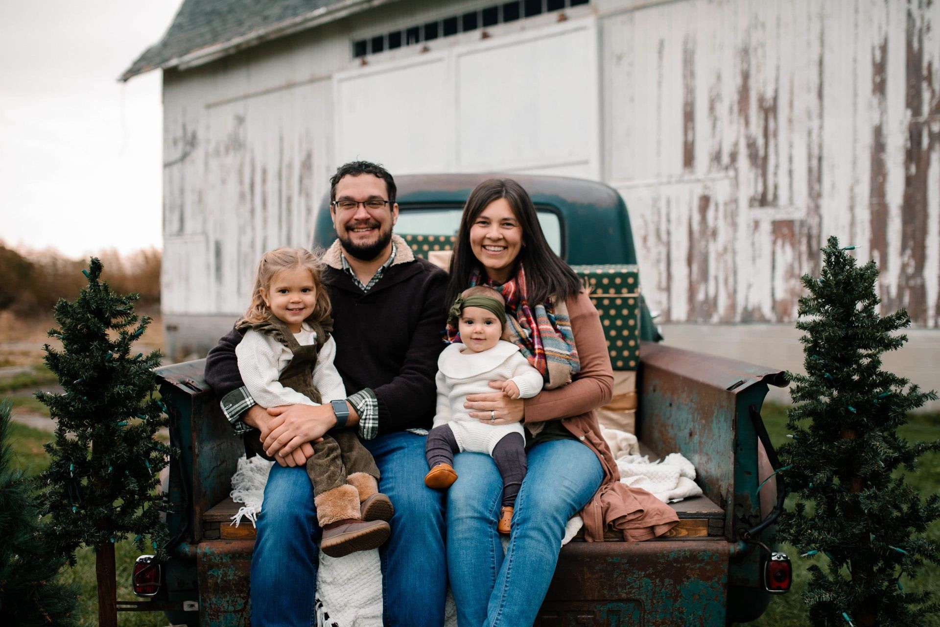 A family is sitting in the back of a truck.