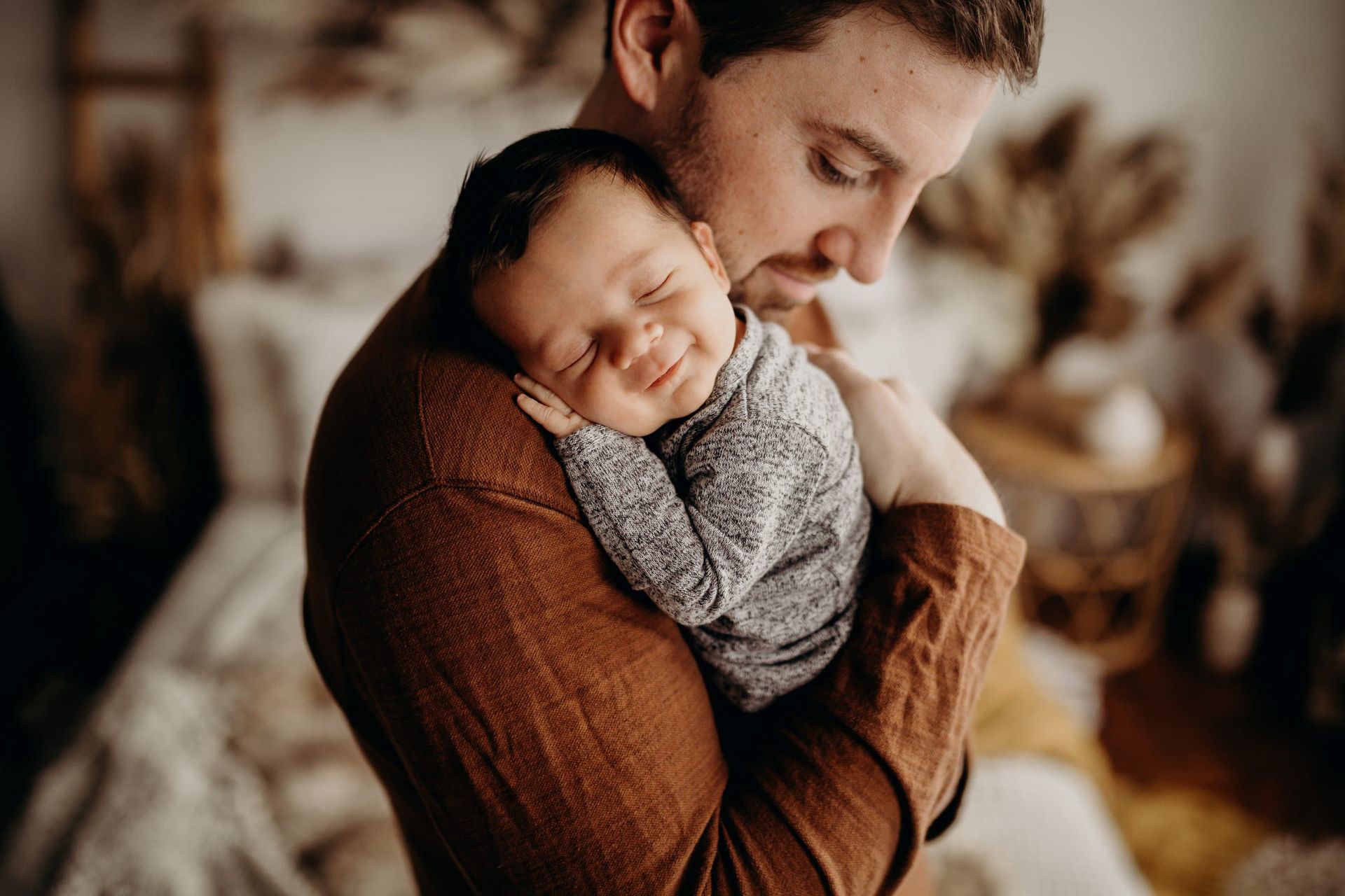 A man is holding a newborn baby in his arms.