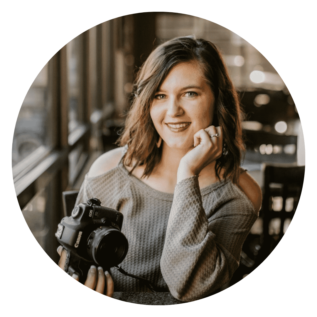 A woman is holding a camera and smiling in a circle.