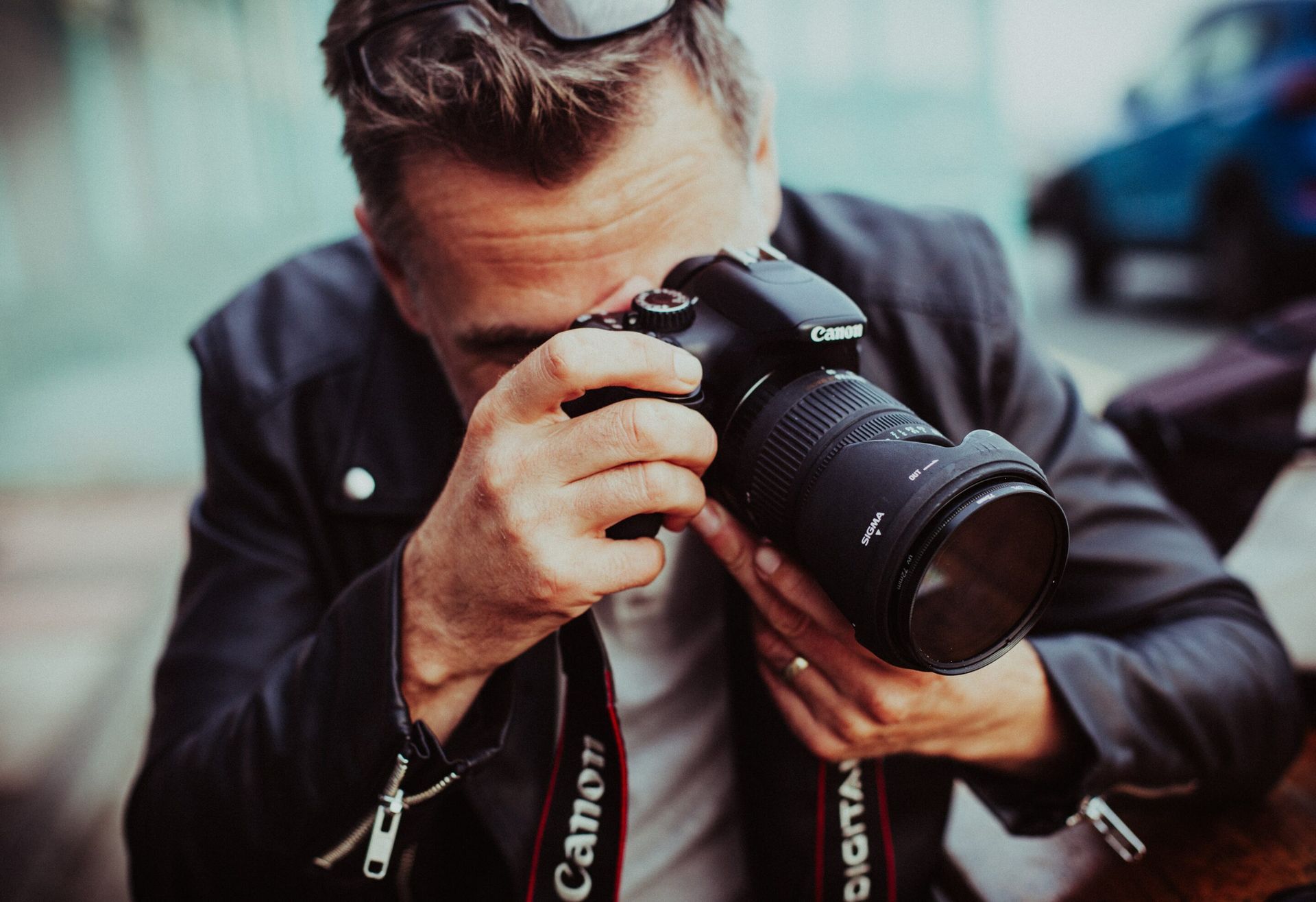 A man is taking a picture with a canon camera