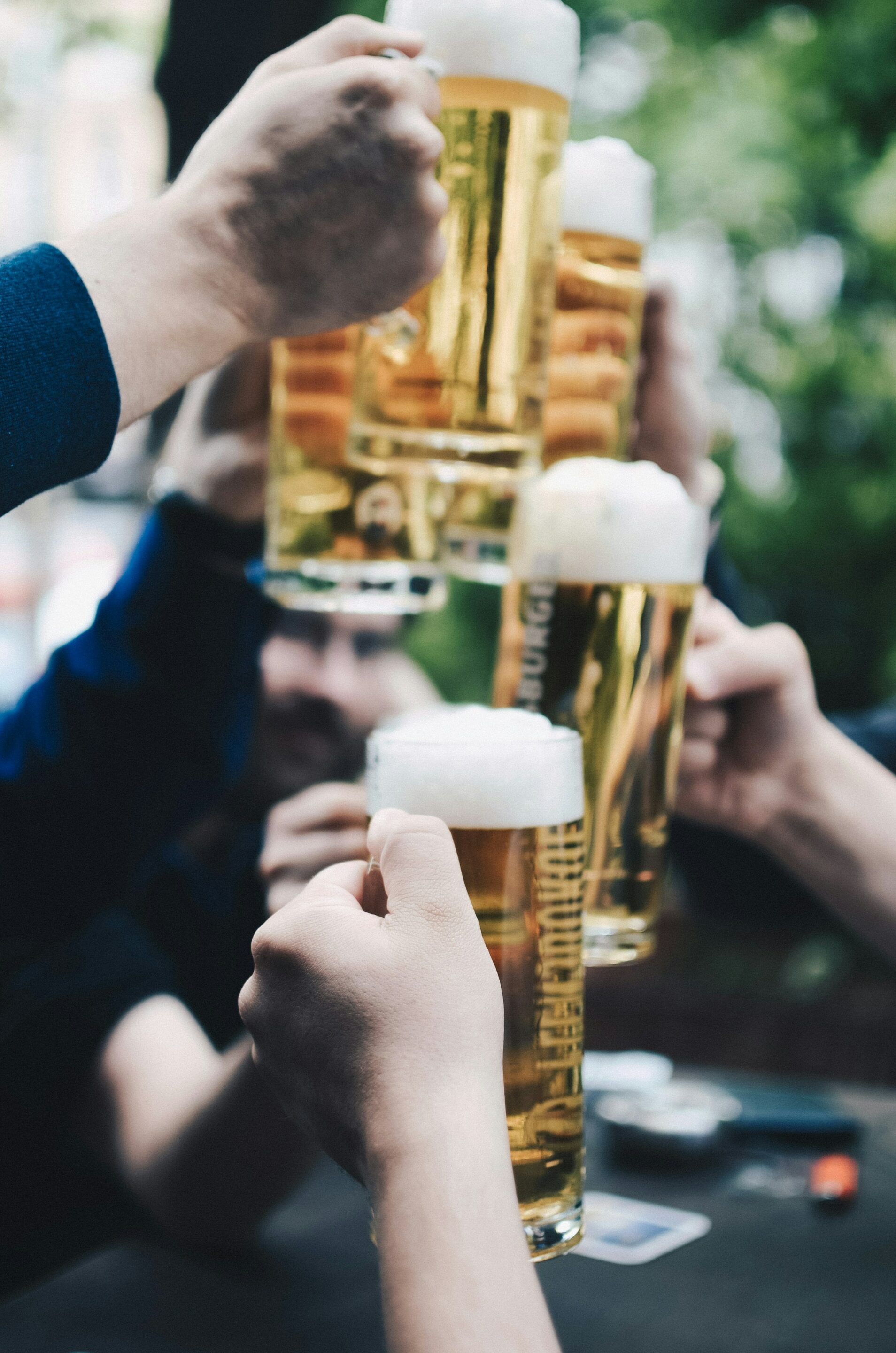 A group of people are toasting with glasses of beer