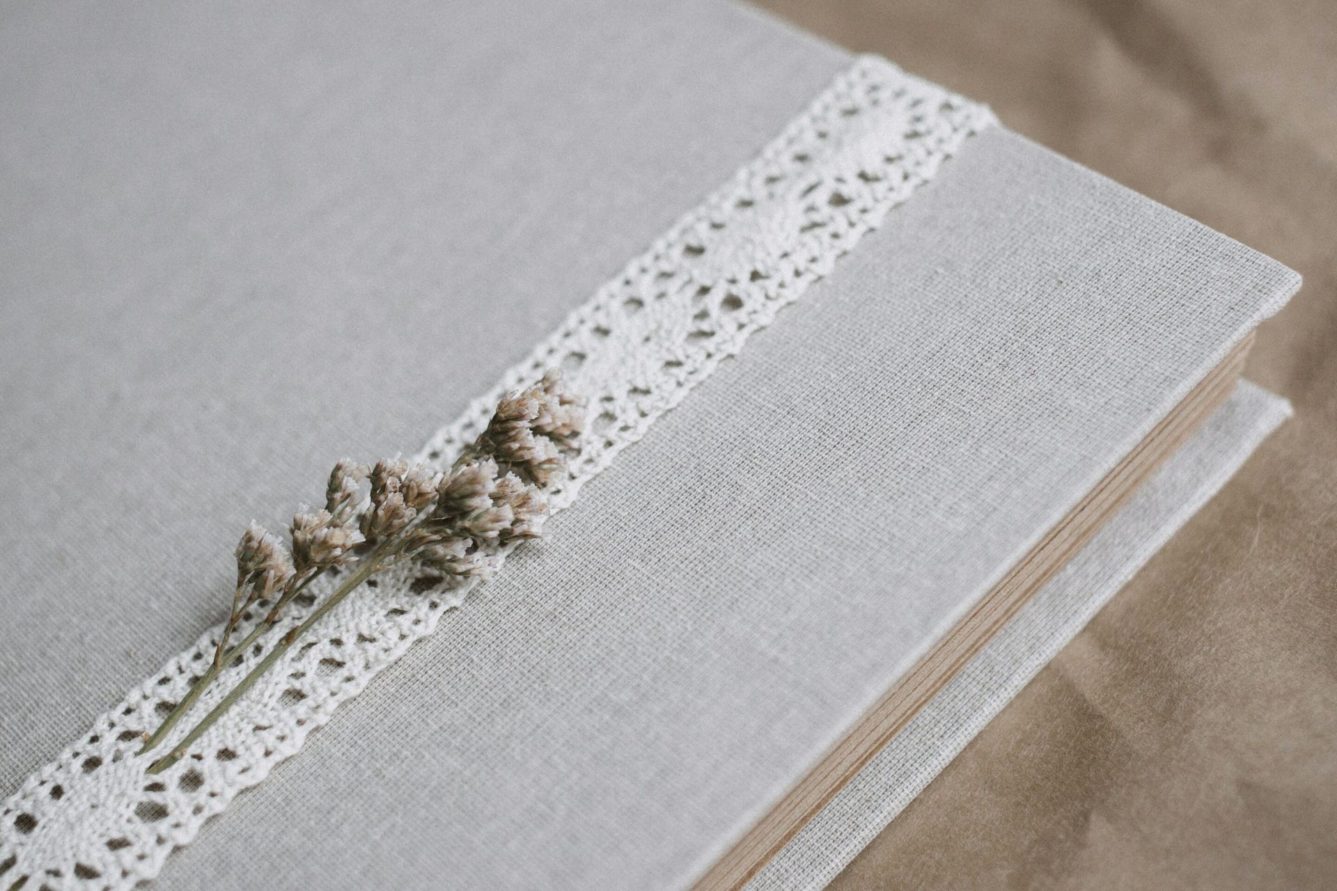 A book with a lace ribbon and dried flowers on it.