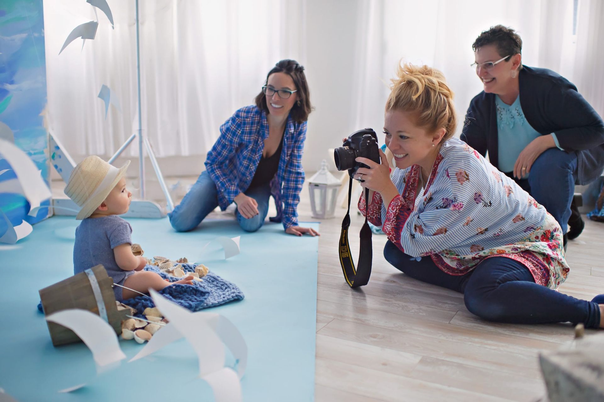 A woman is taking a picture of a baby with a camera.