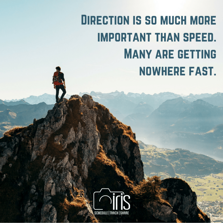 A man standing on top of a mountain with a quote that says direction is so much more important than speed many are getting nowhere fast