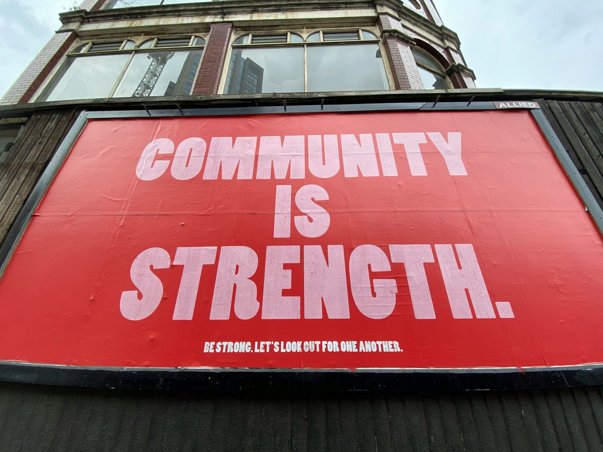 A red sign that says community is strength on it