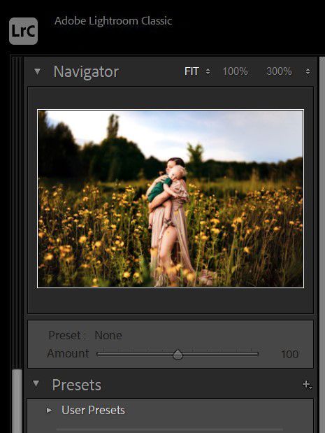 A woman is holding a baby in a field of flowers.