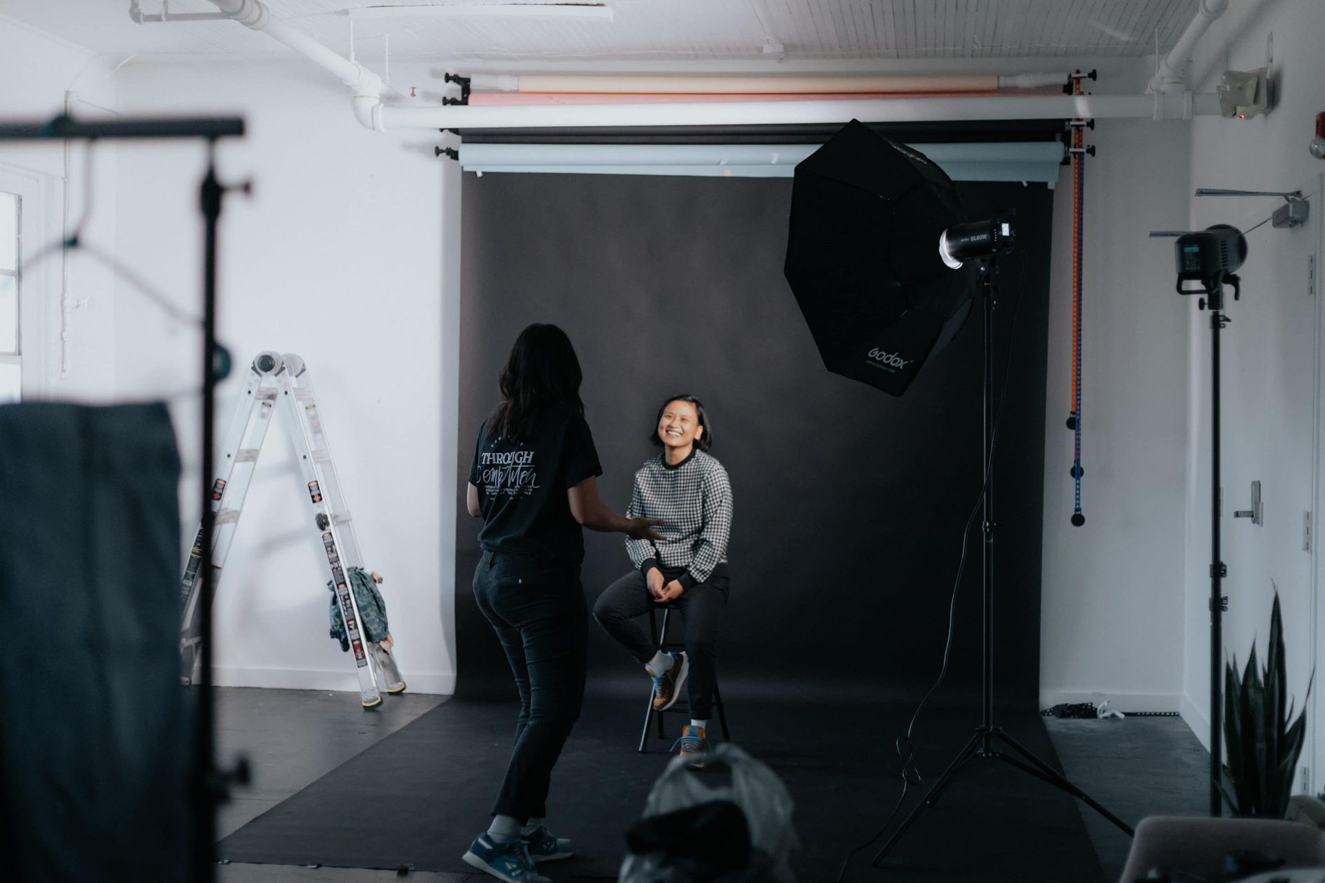 A woman is taking a picture of a child in a photo studio.