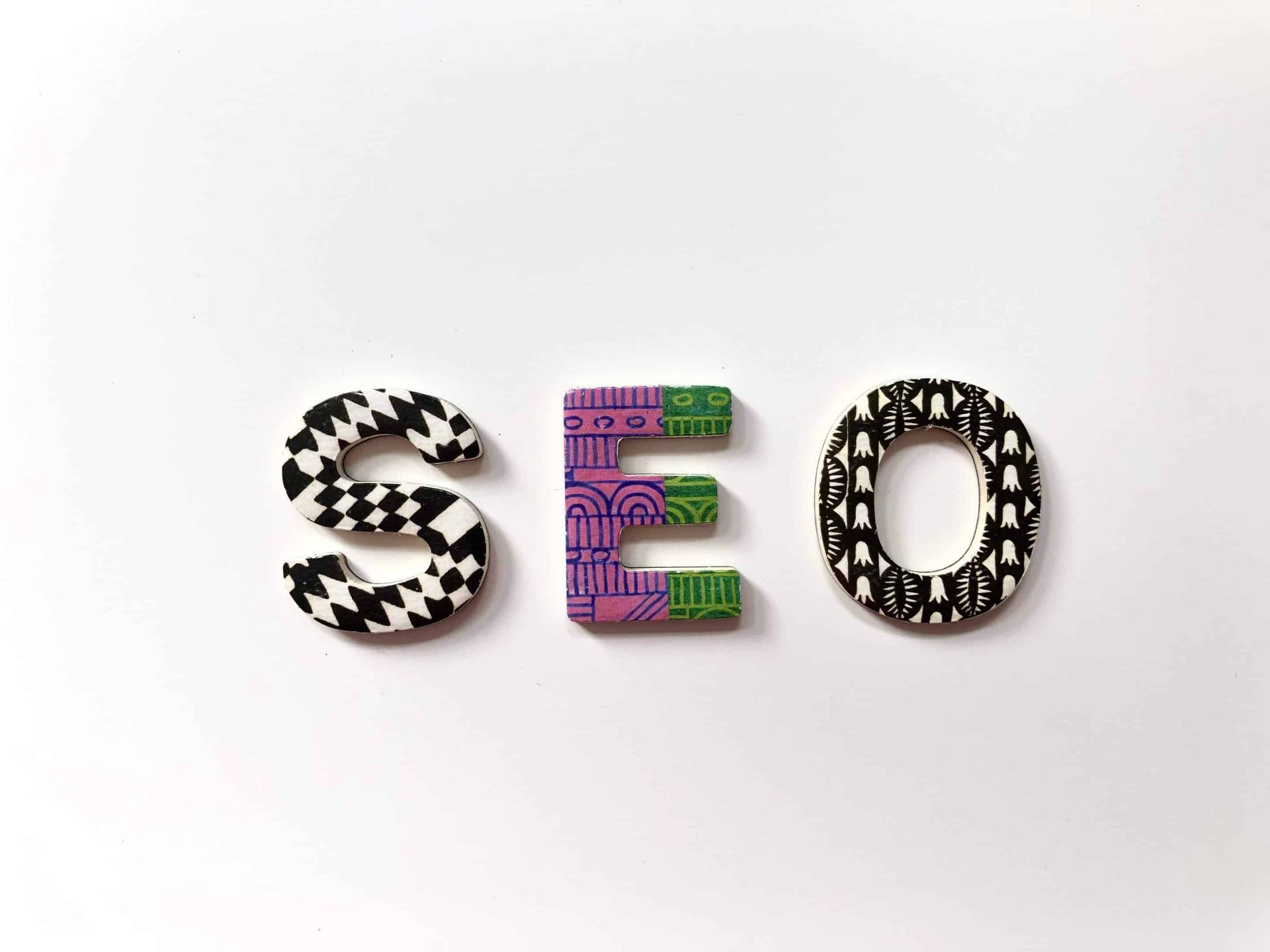 The word seo is written in colorful wooden letters on a white background.