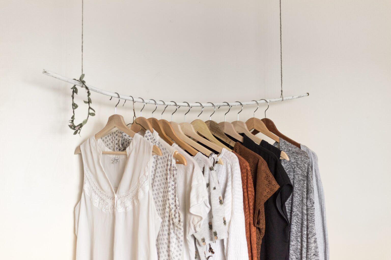 A row of clothes hanging from a clothes rack.