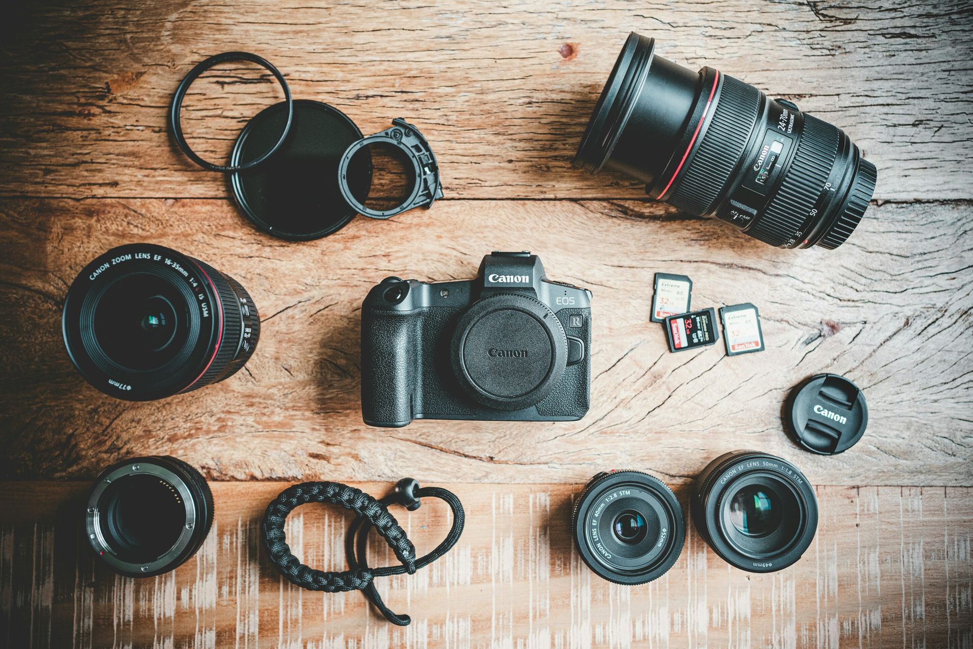 A camera and lenses are sitting on a wooden table.