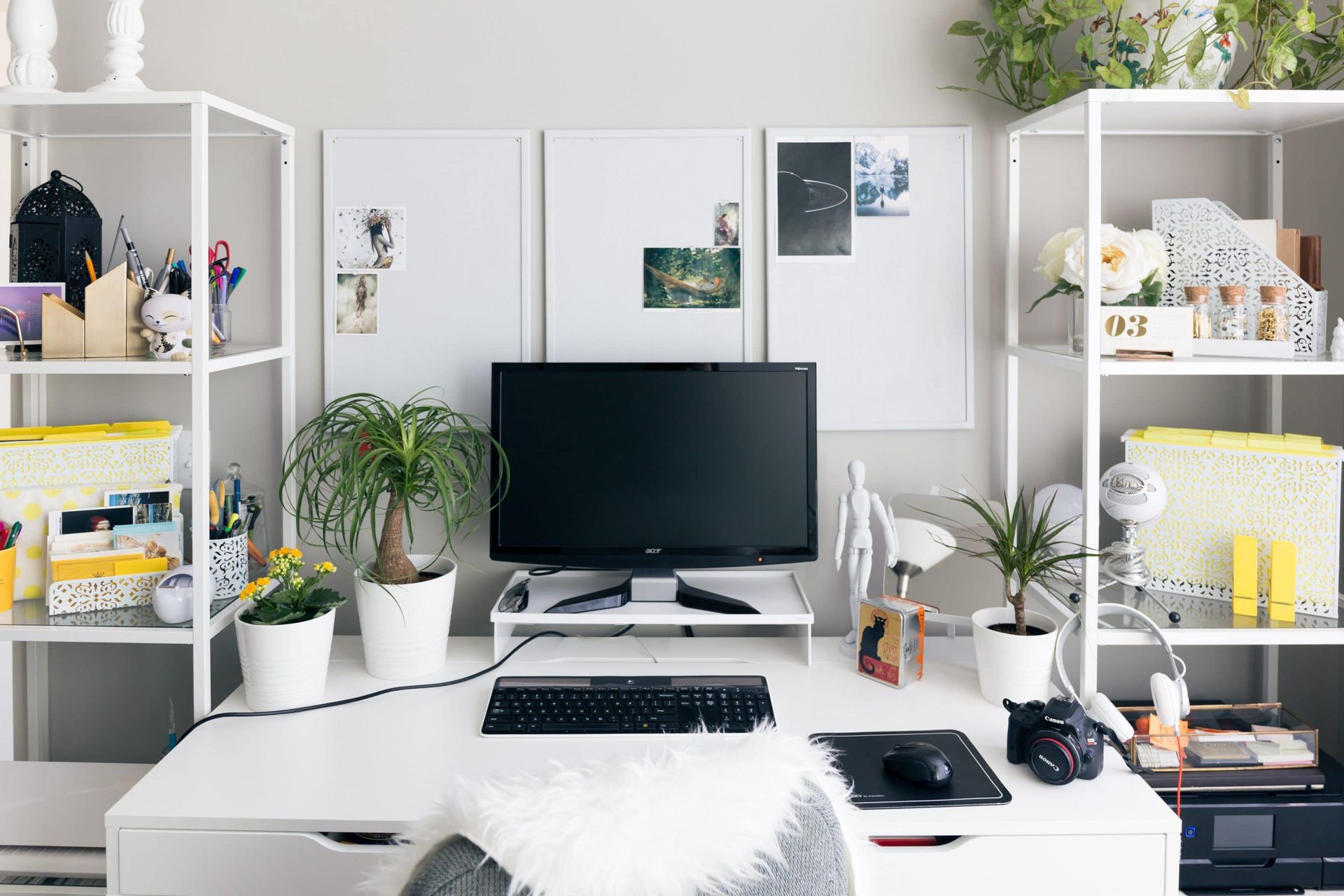 A desk with a computer , keyboard , mouse and plants on it.