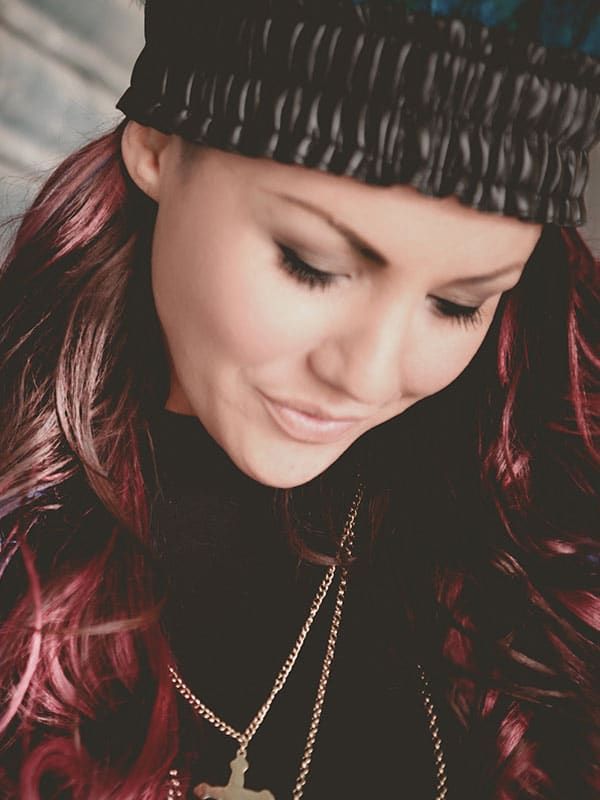 A close up of a woman wearing a hat and necklace