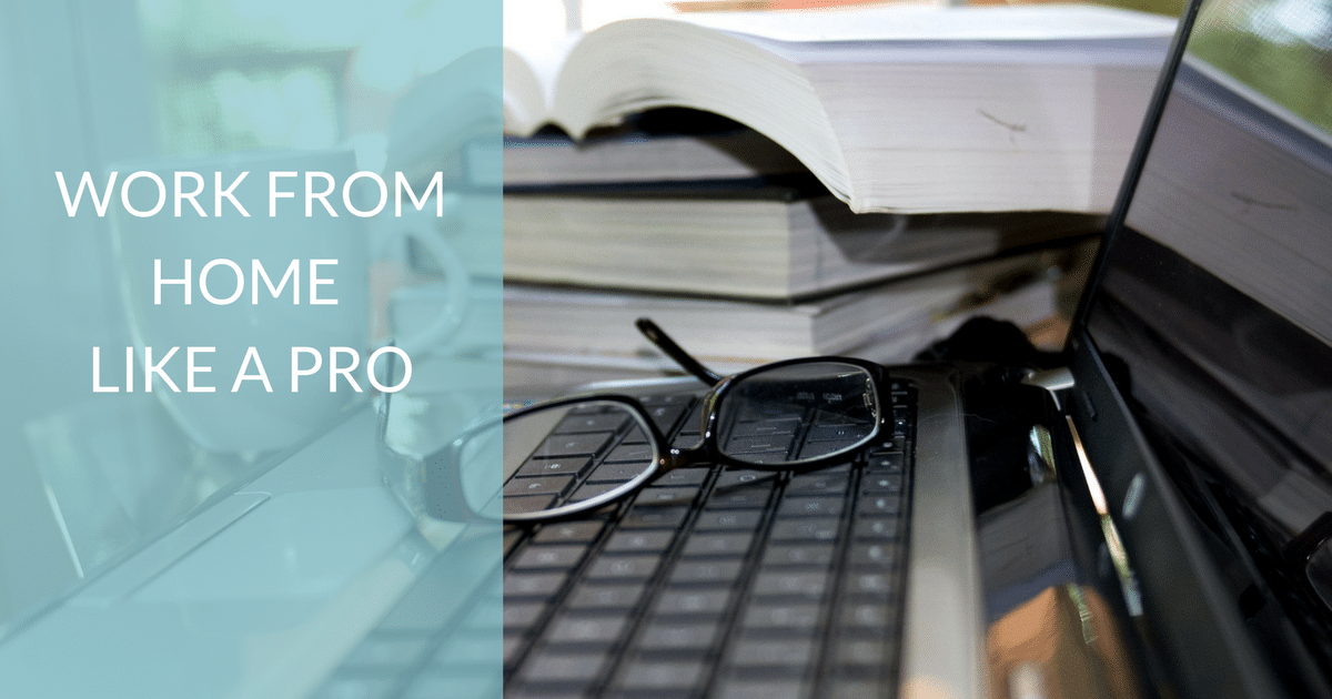 A stack of books and a laptop with glasses on the keyboard.