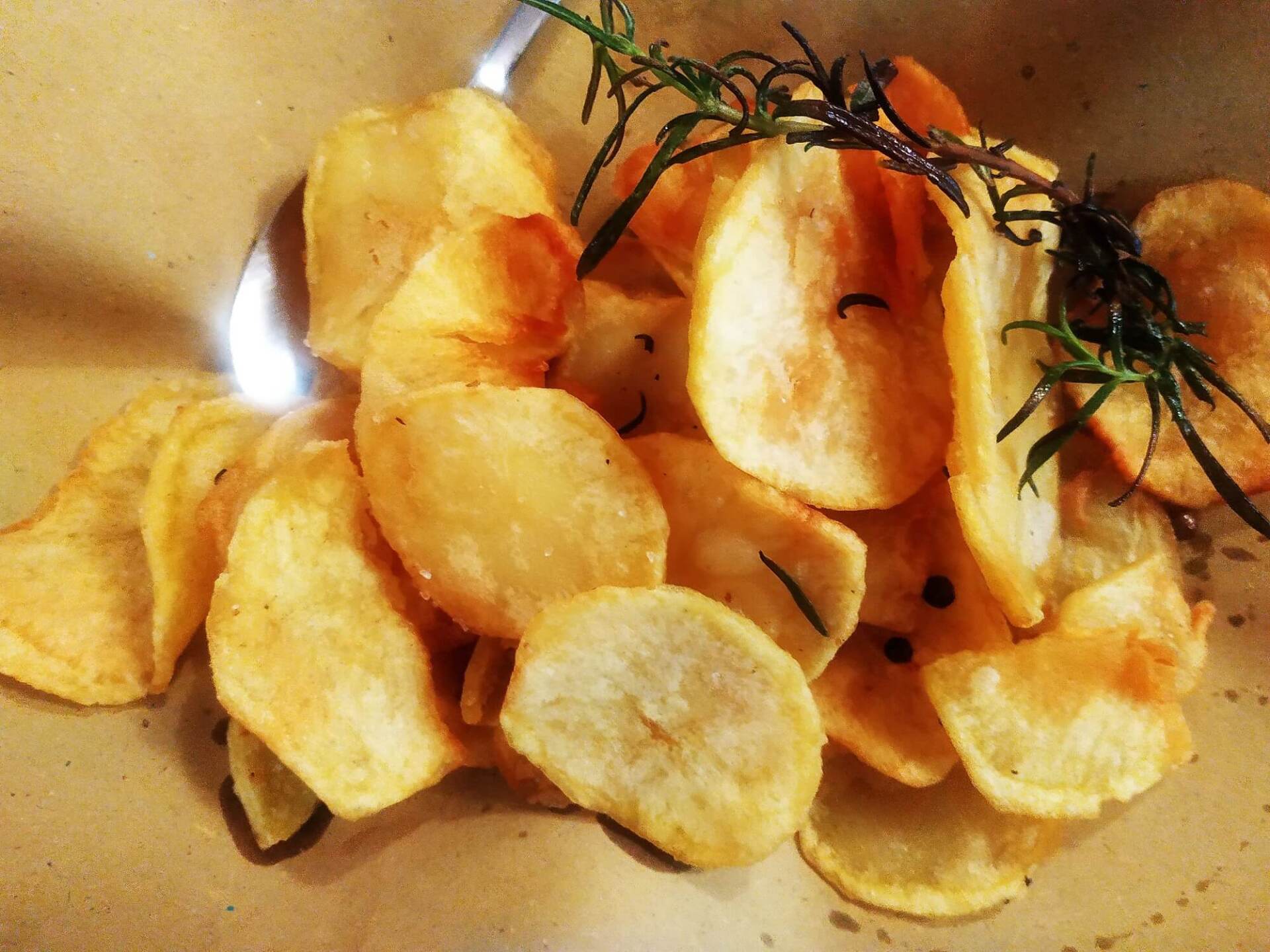 Patatine dorate con rametti di rosmarino.