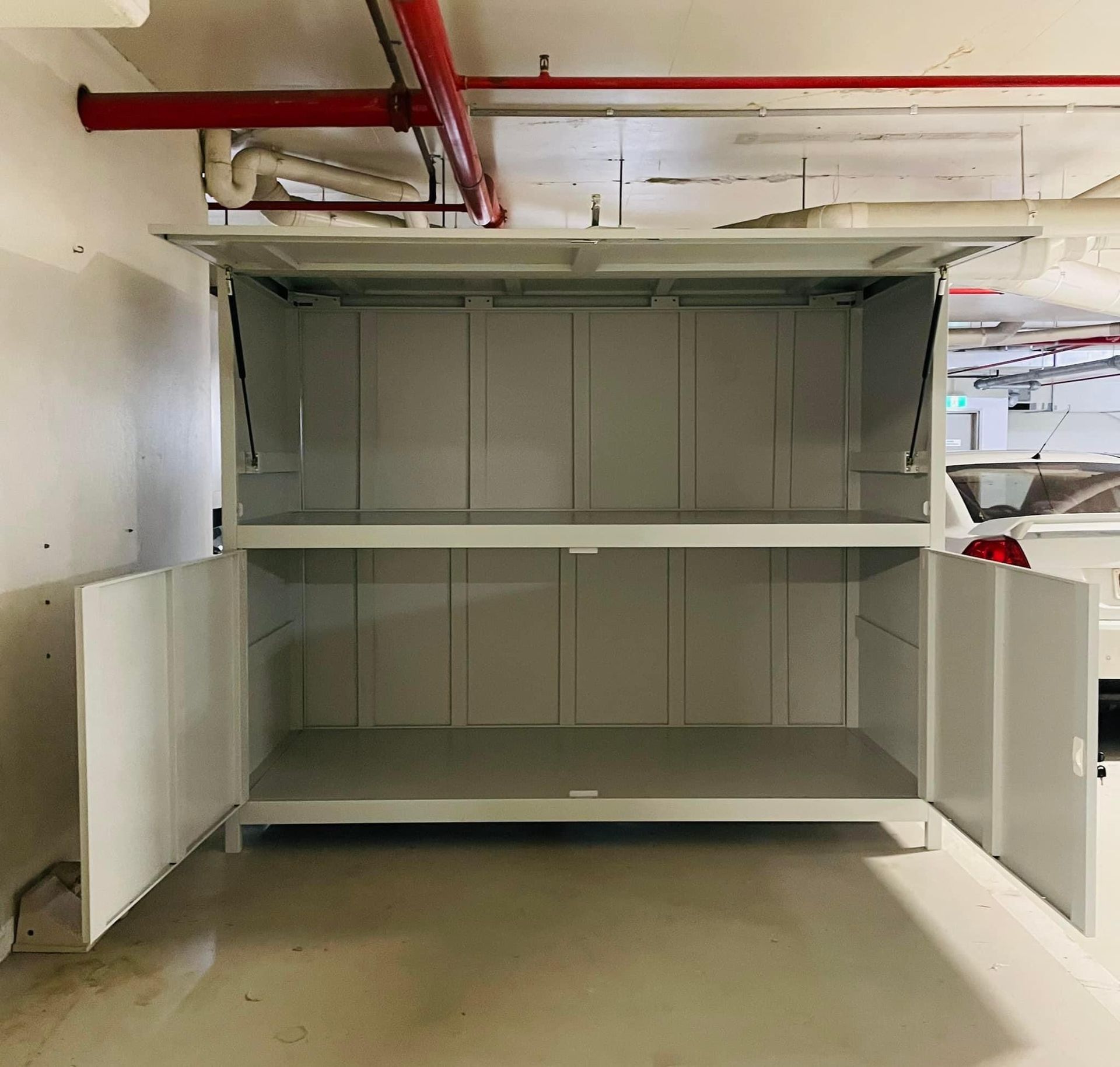 An empty cabinet in a garage with the doors open
