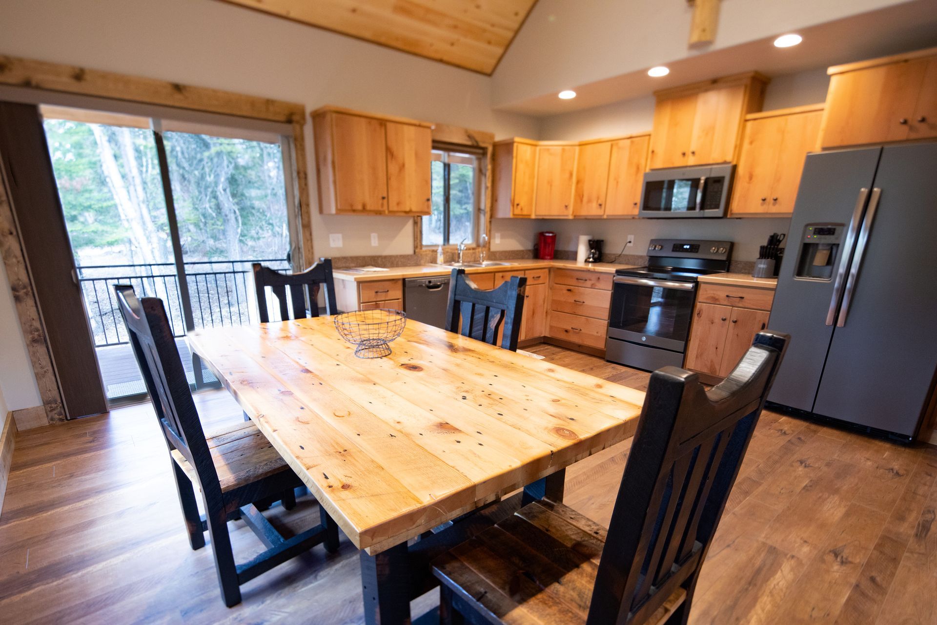 A kitchen with a wooden table and chairs and a refrigerator.