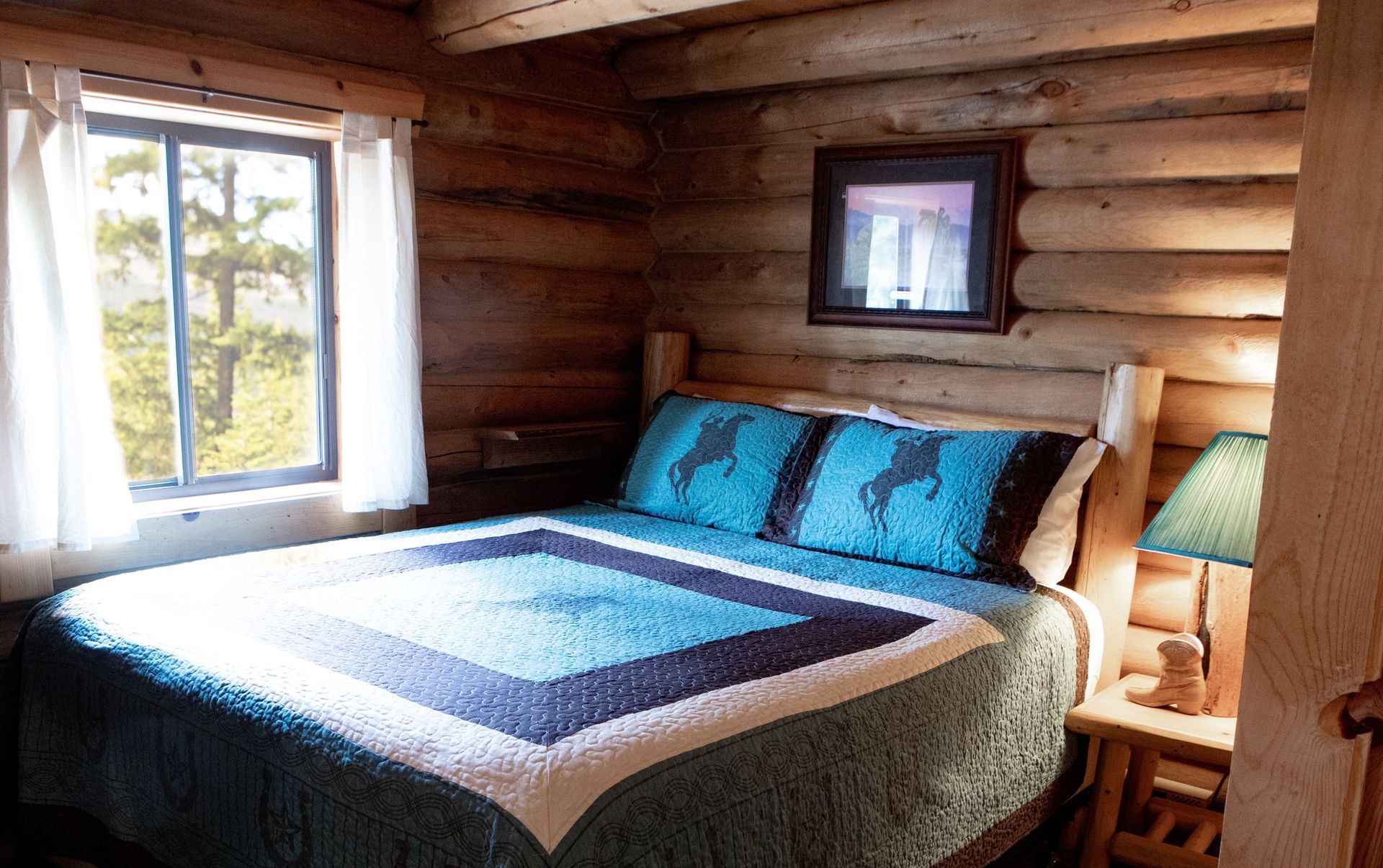 A bedroom in a log cabin with a bed and a window