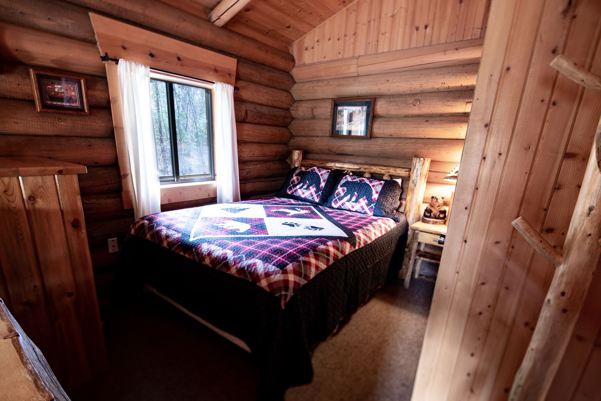 A bedroom in a log cabin with a bed and a window