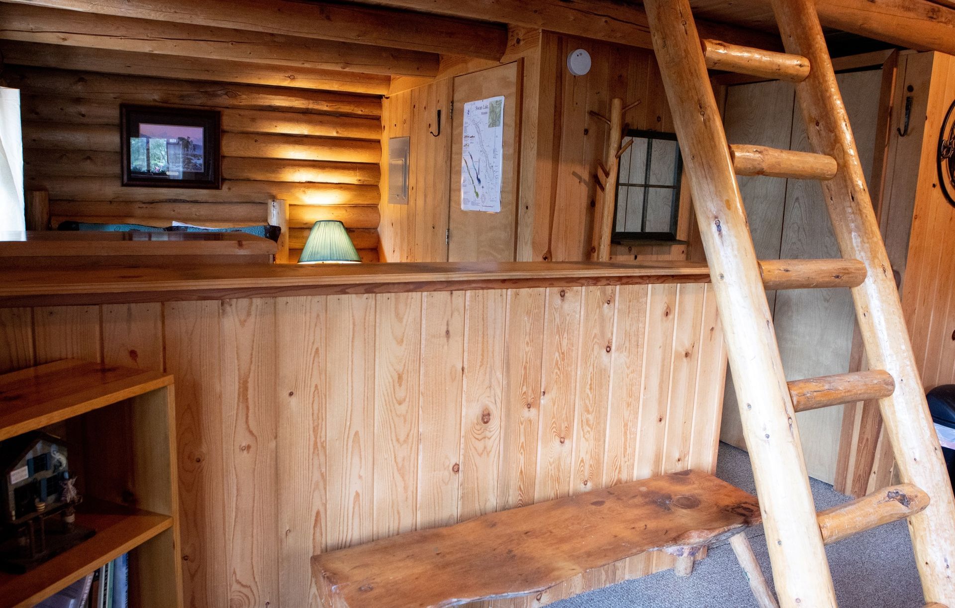A wooden cabin with a ladder leading up to the second floor.