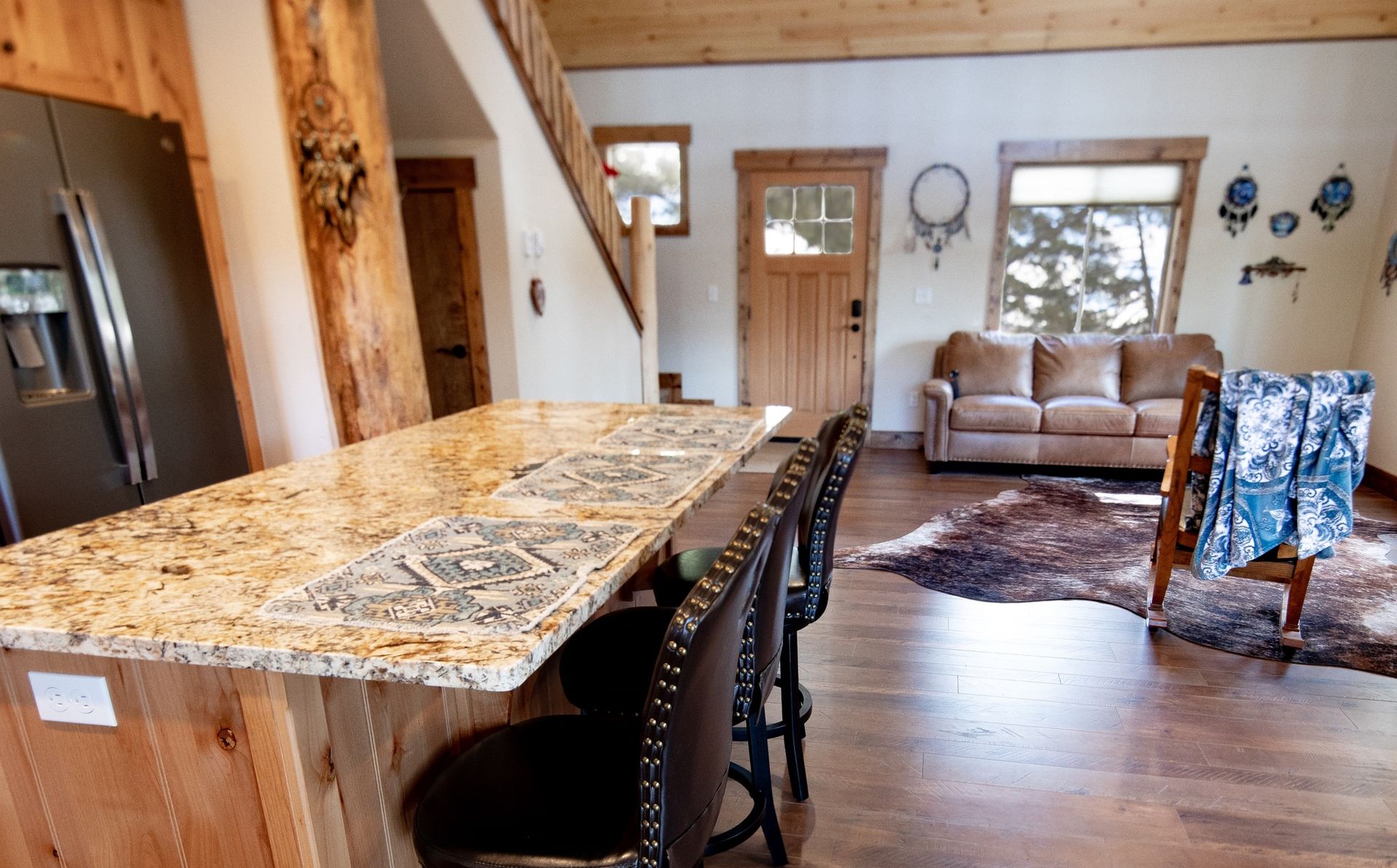 A kitchen with a granite counter top and a couch in the background.