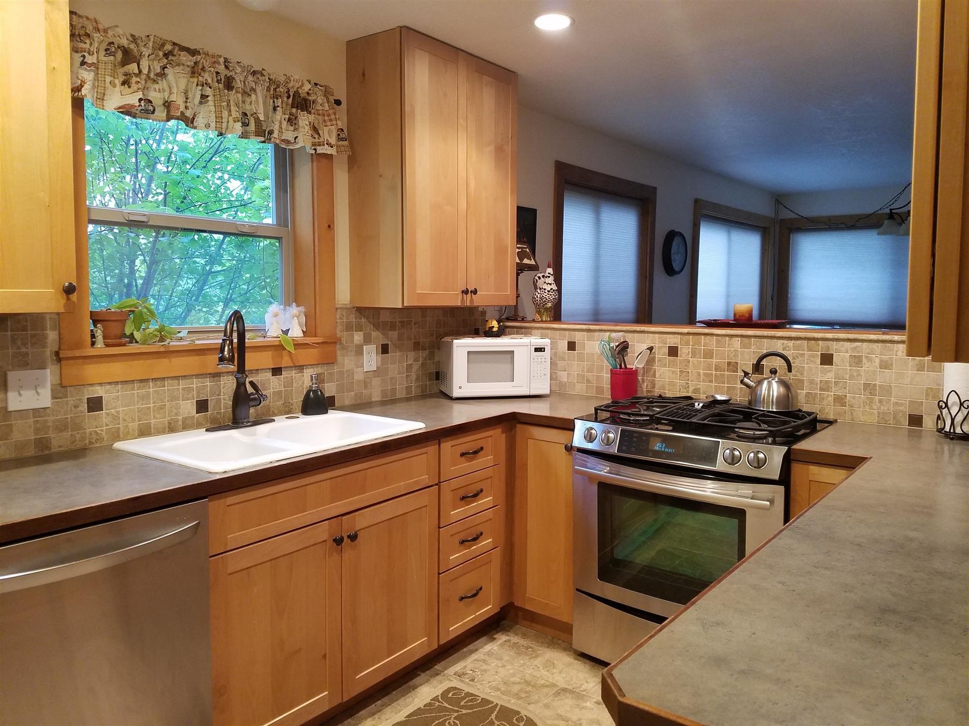 A kitchen with stainless steel appliances and wooden cabinets