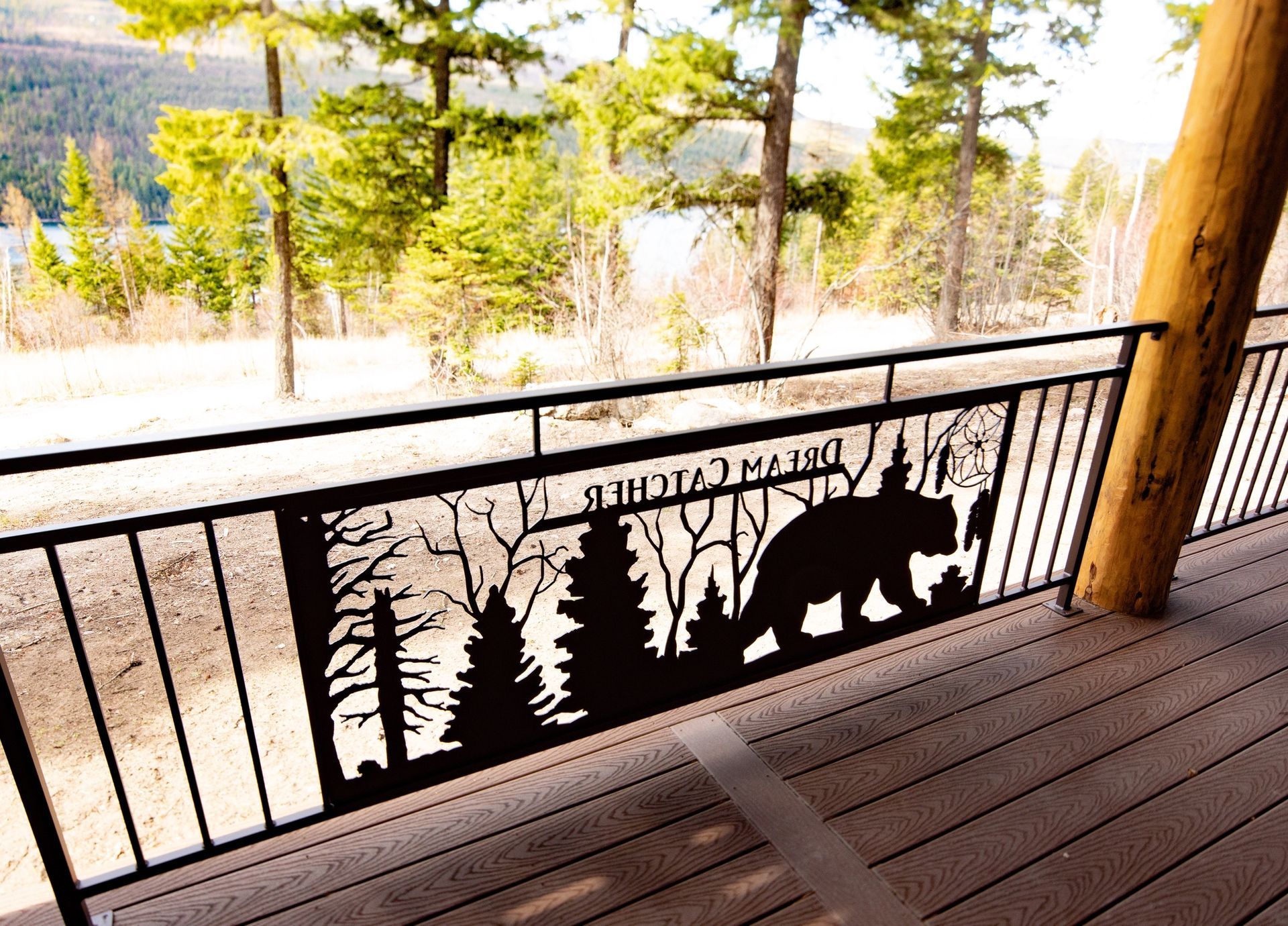 A railing with a bear and trees on it