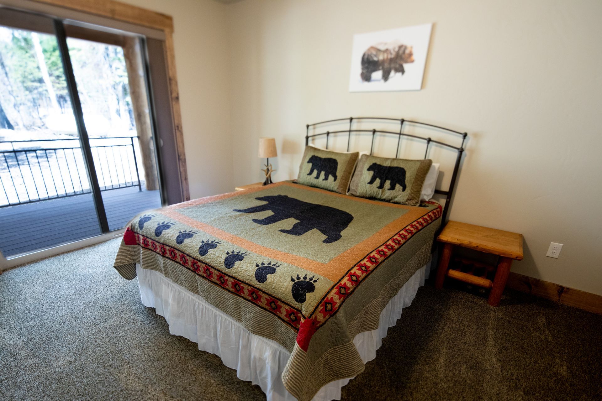 A bedroom with a king size bed and a sliding glass door.