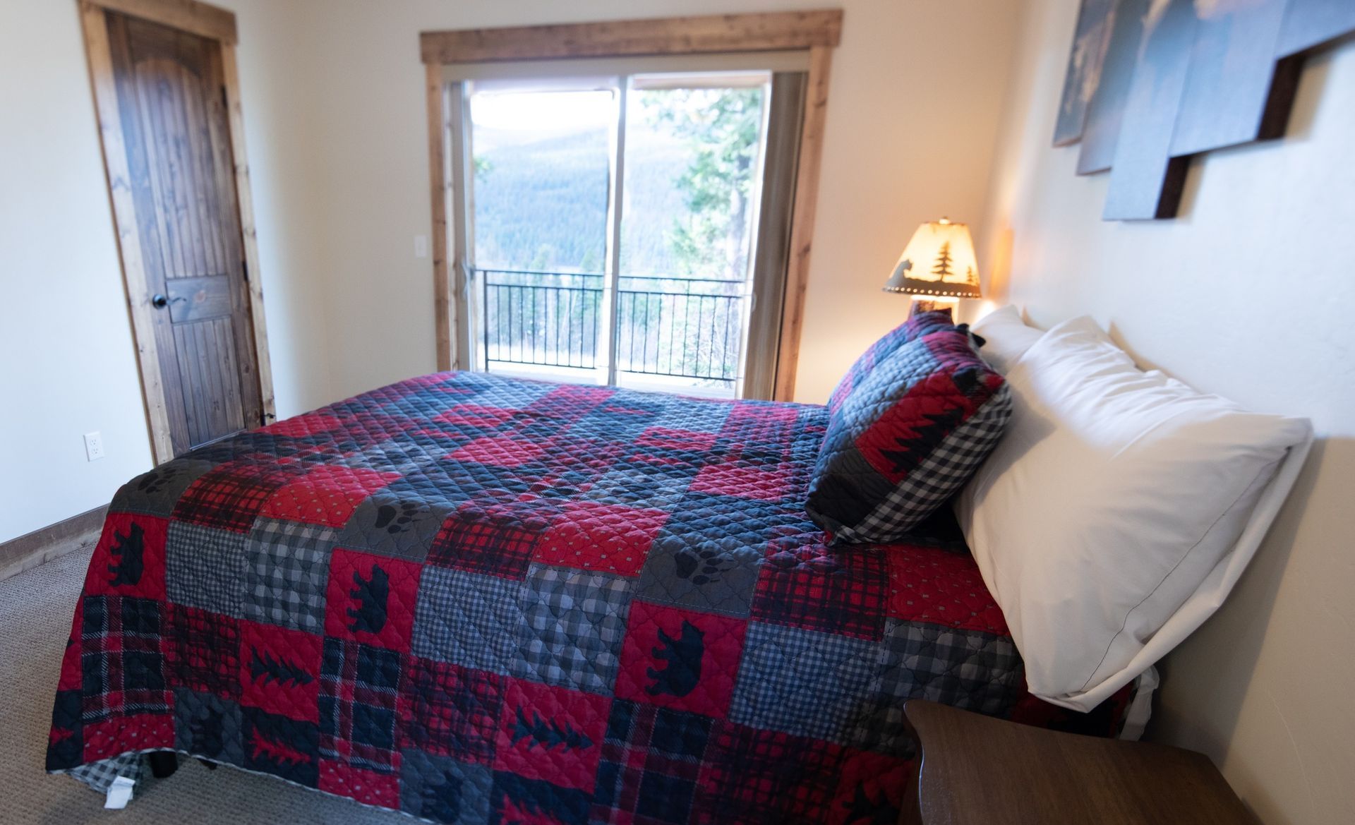 A bedroom with a king size bed and a sliding glass door