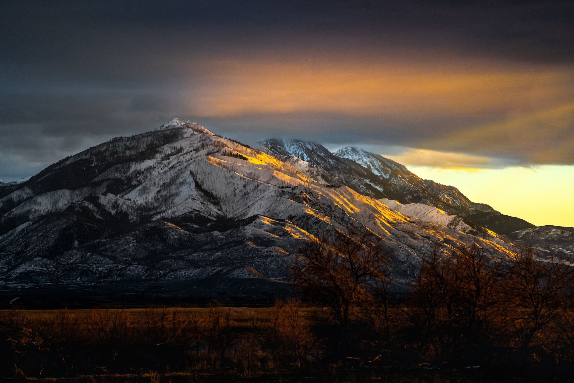 A snowy mountain with a sunset in the background