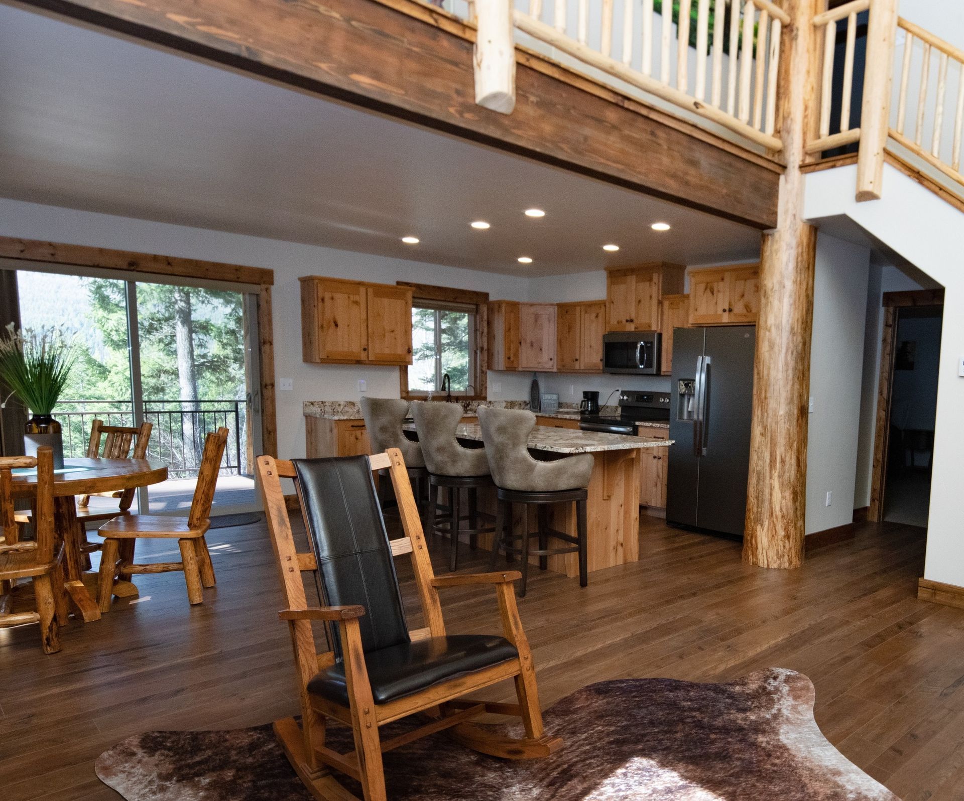 A living room with a rocking chair and a cowhide rug