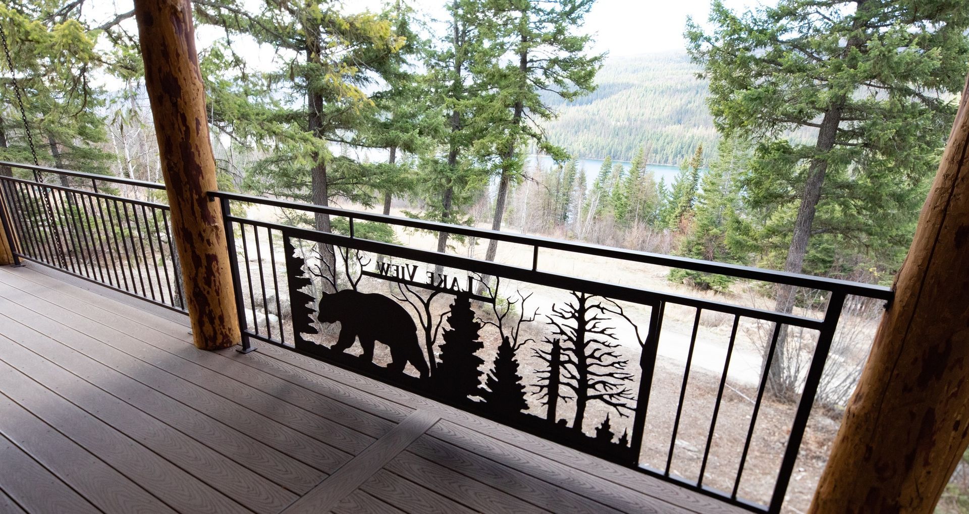 A balcony with a railing with a bear and trees on it.