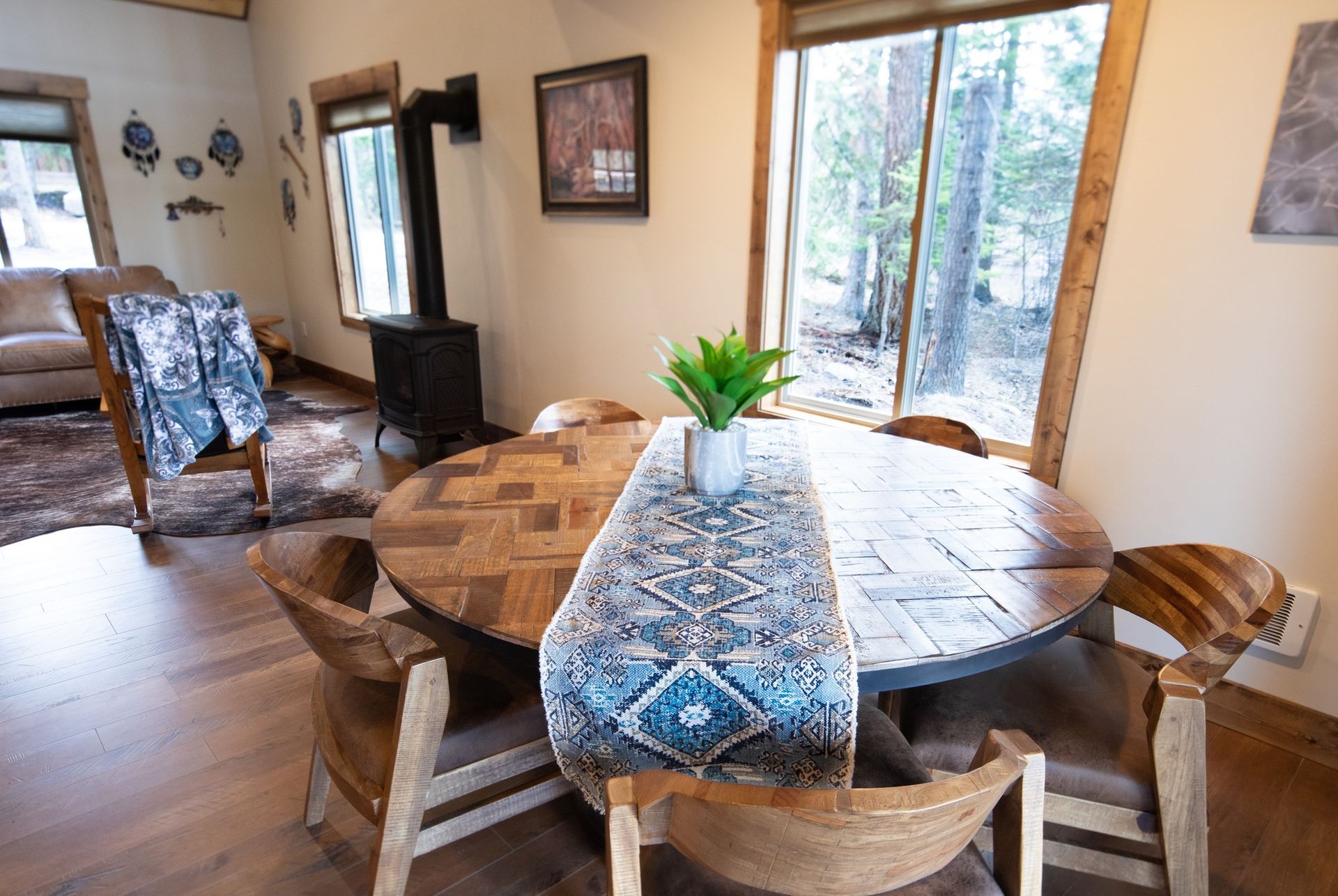 A dining room table with a blue table runner and chairs in a house.