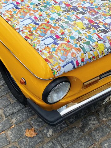 Yellow car hood covered in The Simpsons cartoon characters.