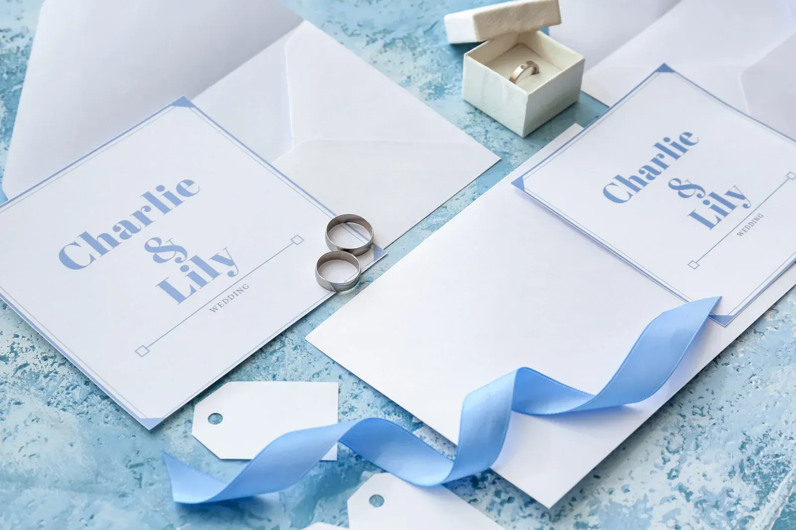 Wedding invitation stationery with blue accents and rings.