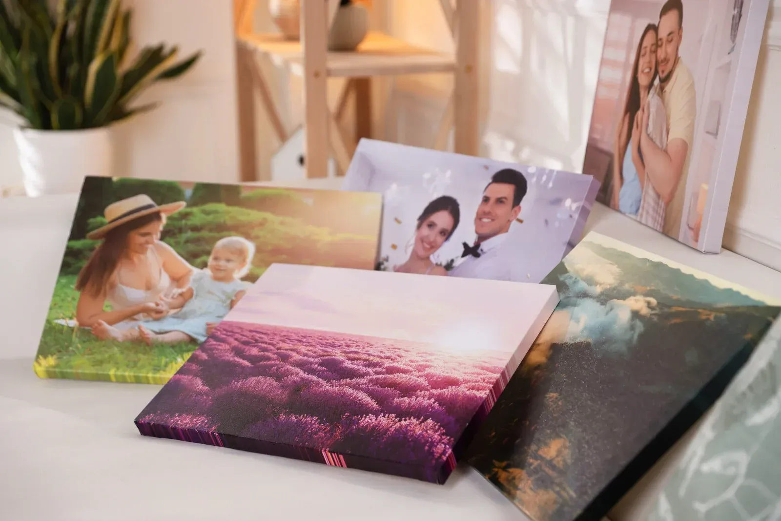 Canvas prints with various images, including portraits and landscapes, displayed on a surface.