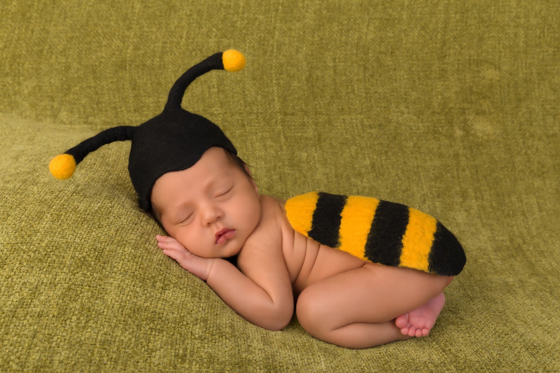 Tiny sleeping baby dressed as a bumble bee