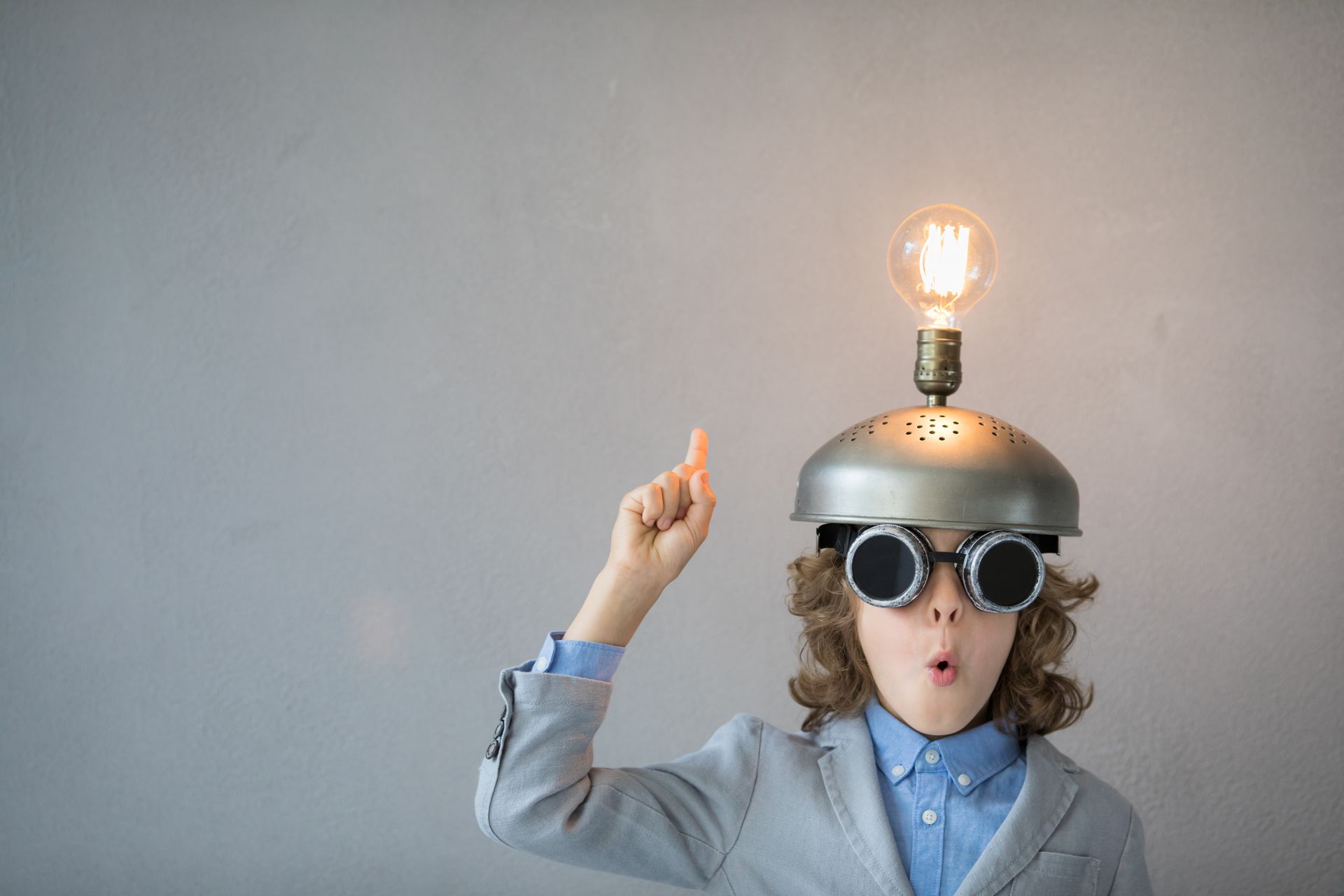 A young boy wearing a helmet with a light bulb on top of it.