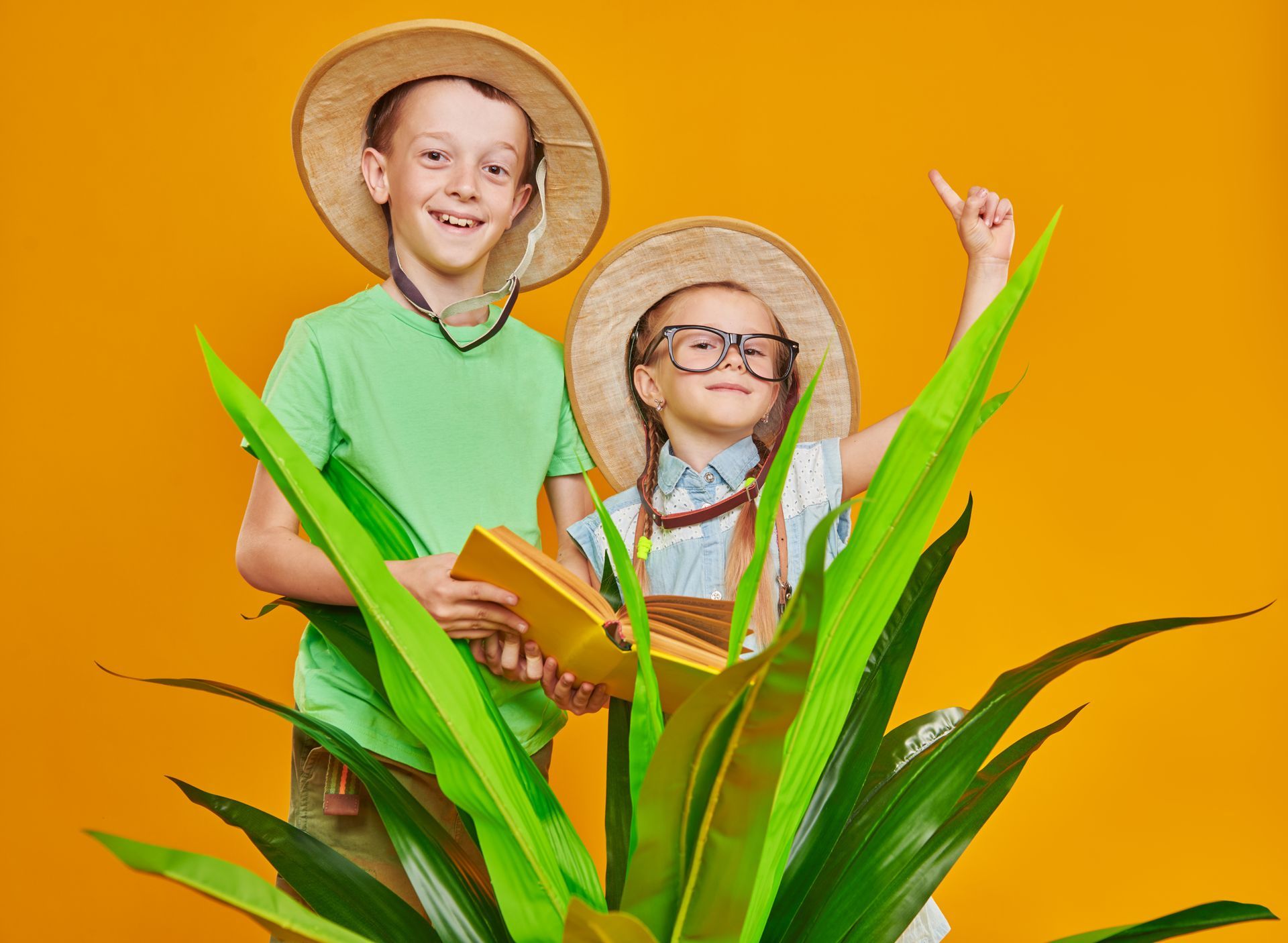 Two boys wearing straw hats pretending to be jungle explorers