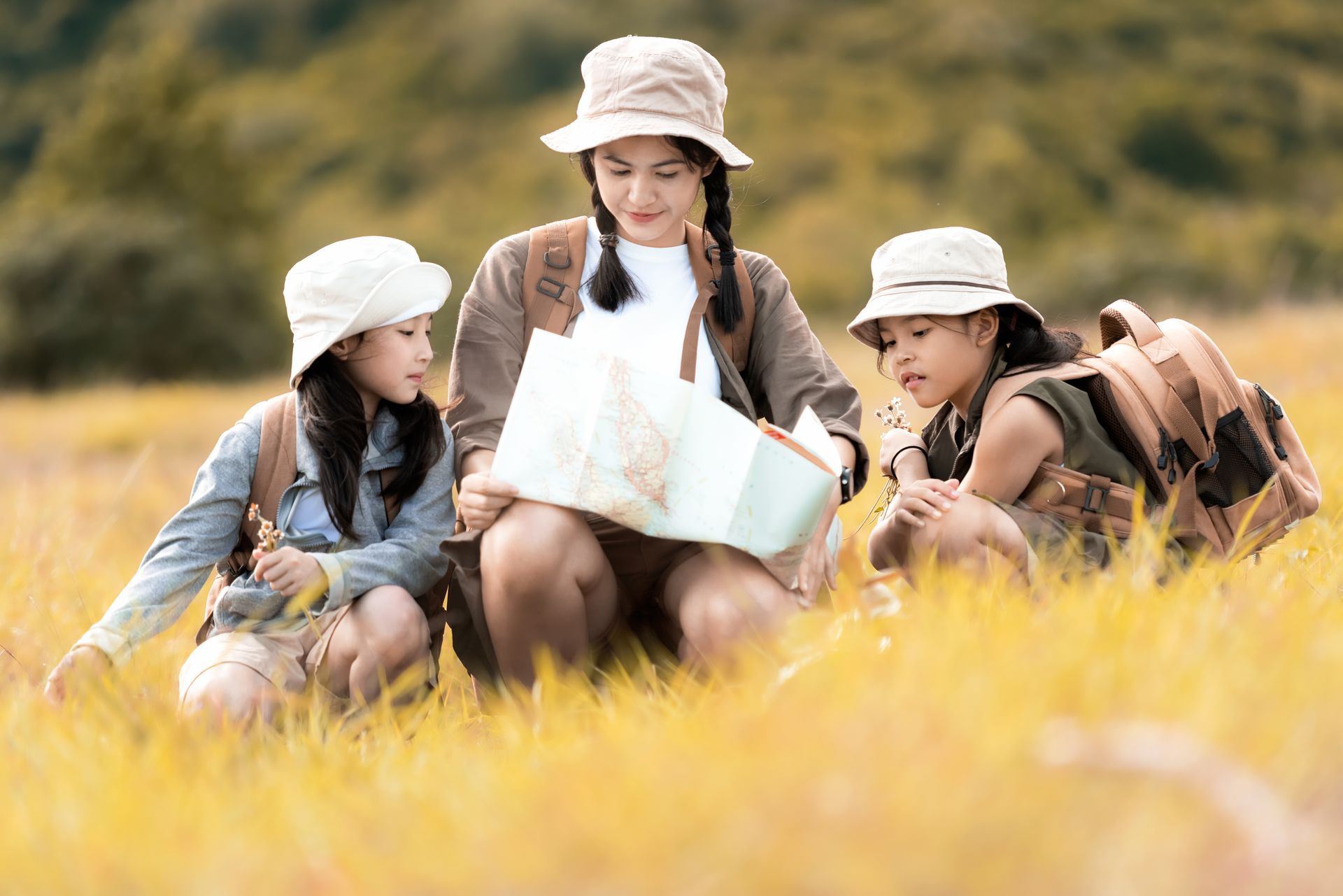 Group of children in a grassy field examining a map