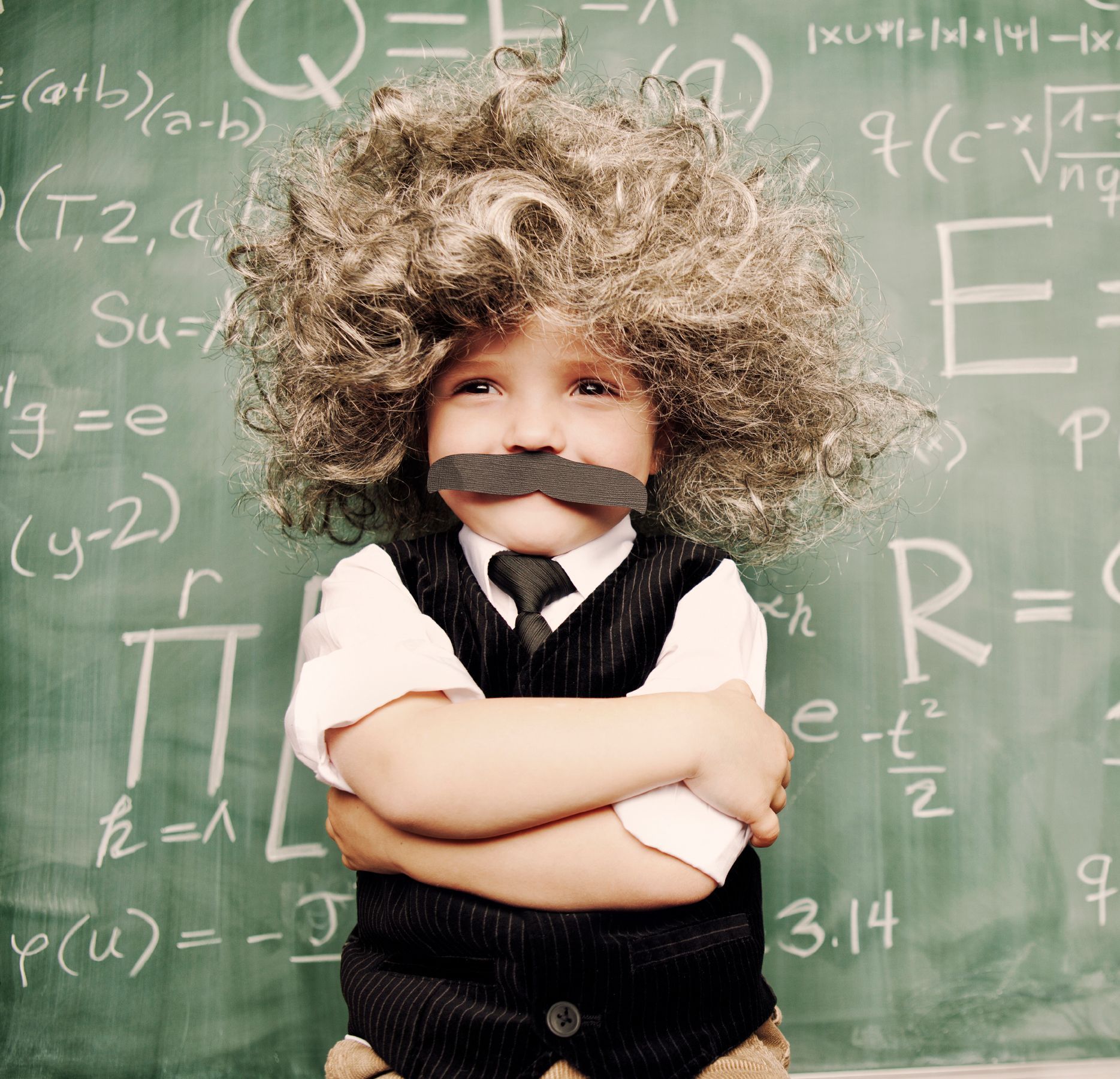 Little boy dressed up as Albert Einstein with messy hair and a moustache