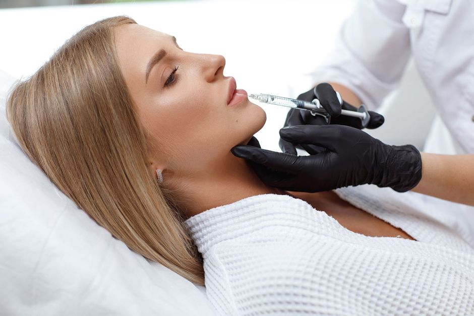A woman is getting a botox injection in her face.