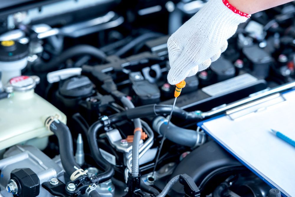 A Person Is Checking The Oil Level In A Car Engine — Weyba Automotive Services In Kuluin, QLD