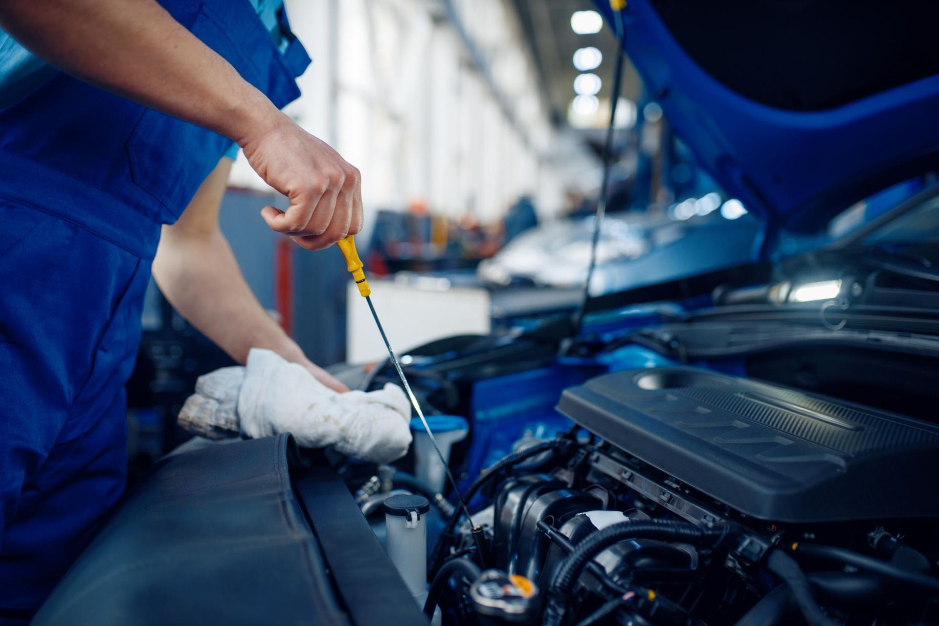 A Mechanic Is Checking The Oil Level Of A Car In A Garage — Weyba Automotive Services In Sunshine Coast, QLD